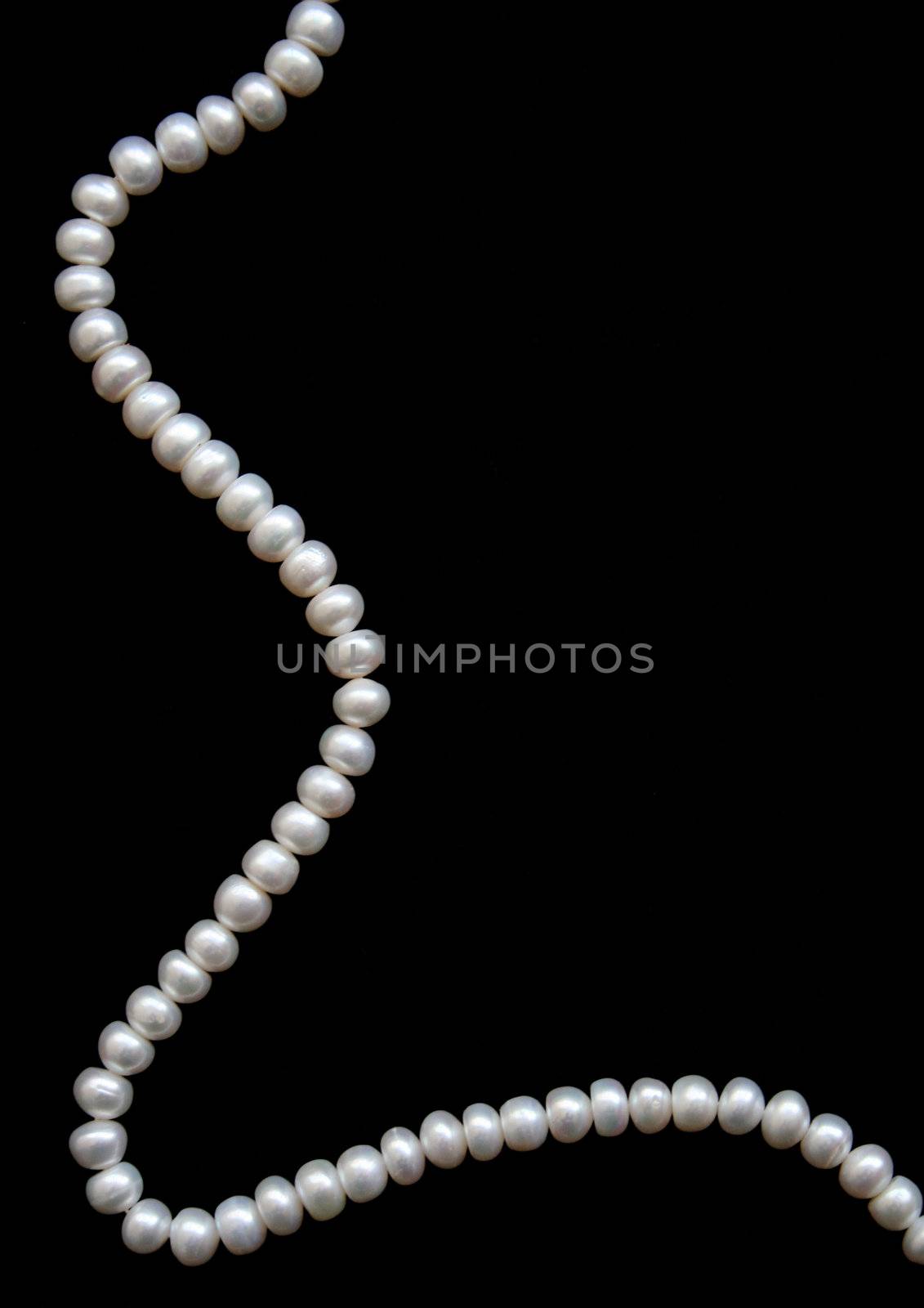 White pearls on a black velvet background 