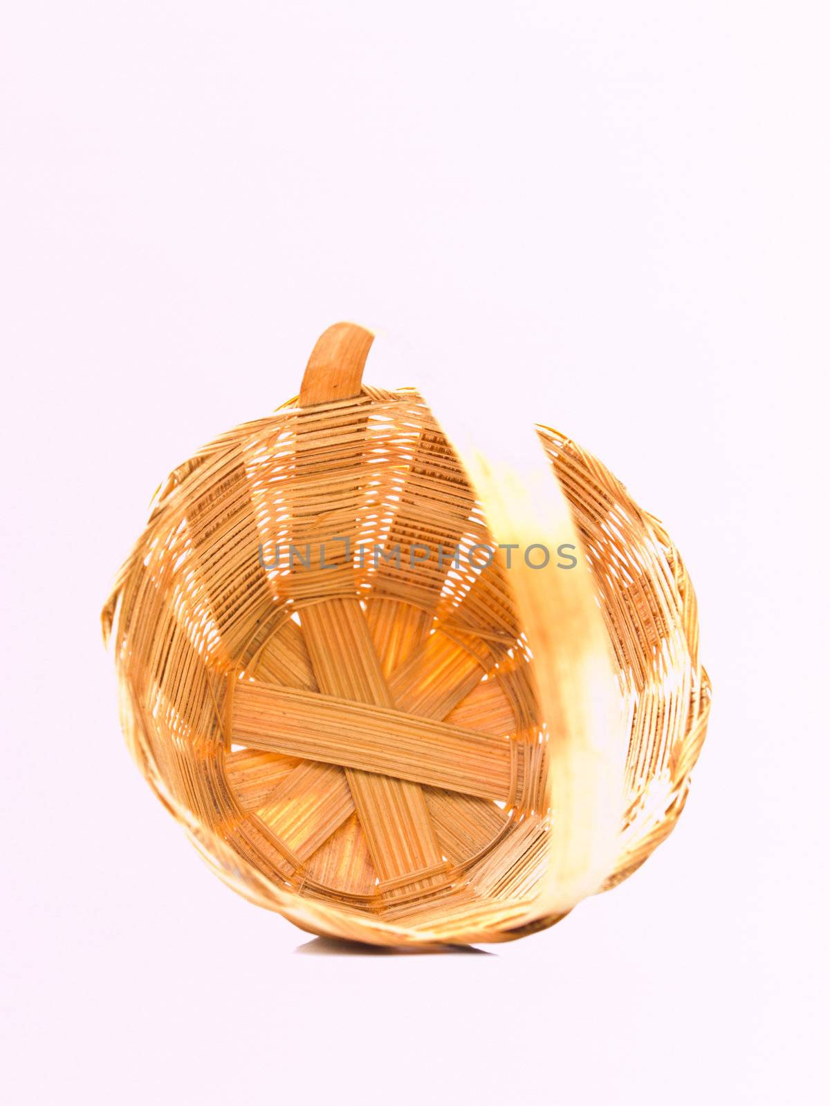 A yellow wicker basket isolated on white background
