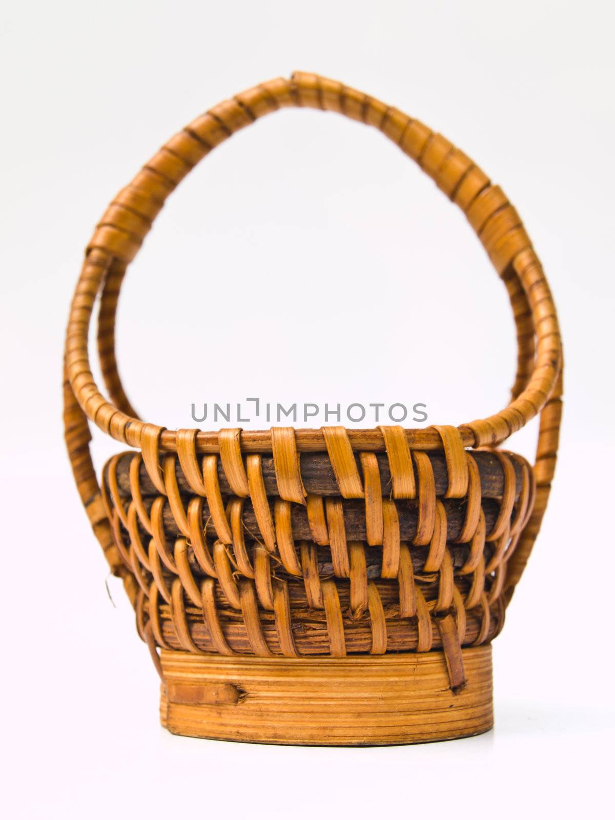 A yellow wicker basket isolated on white background