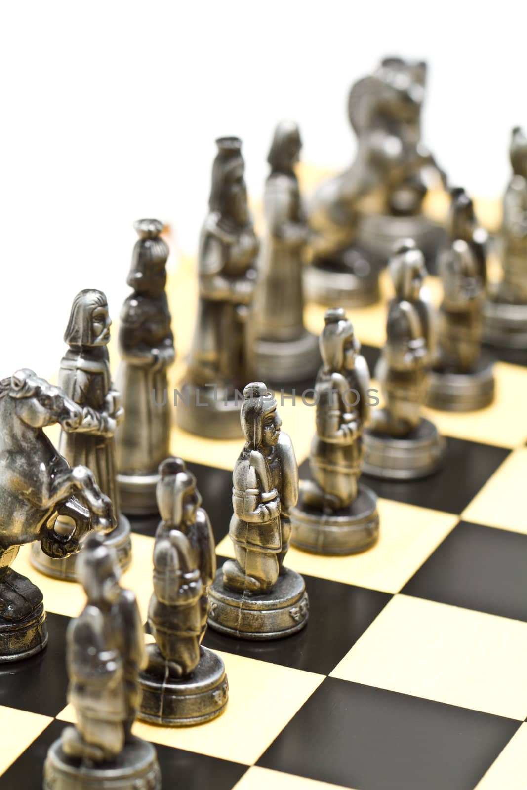 silver chess pieces on a checkerboard with white background