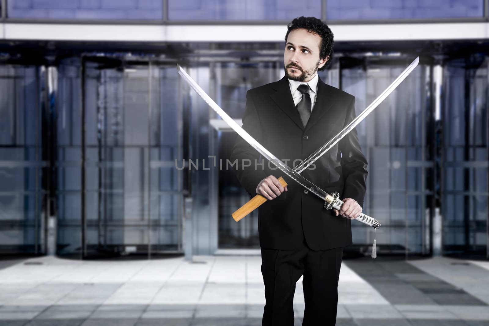 Businessman with two Japanese swords at the entrance of an office building