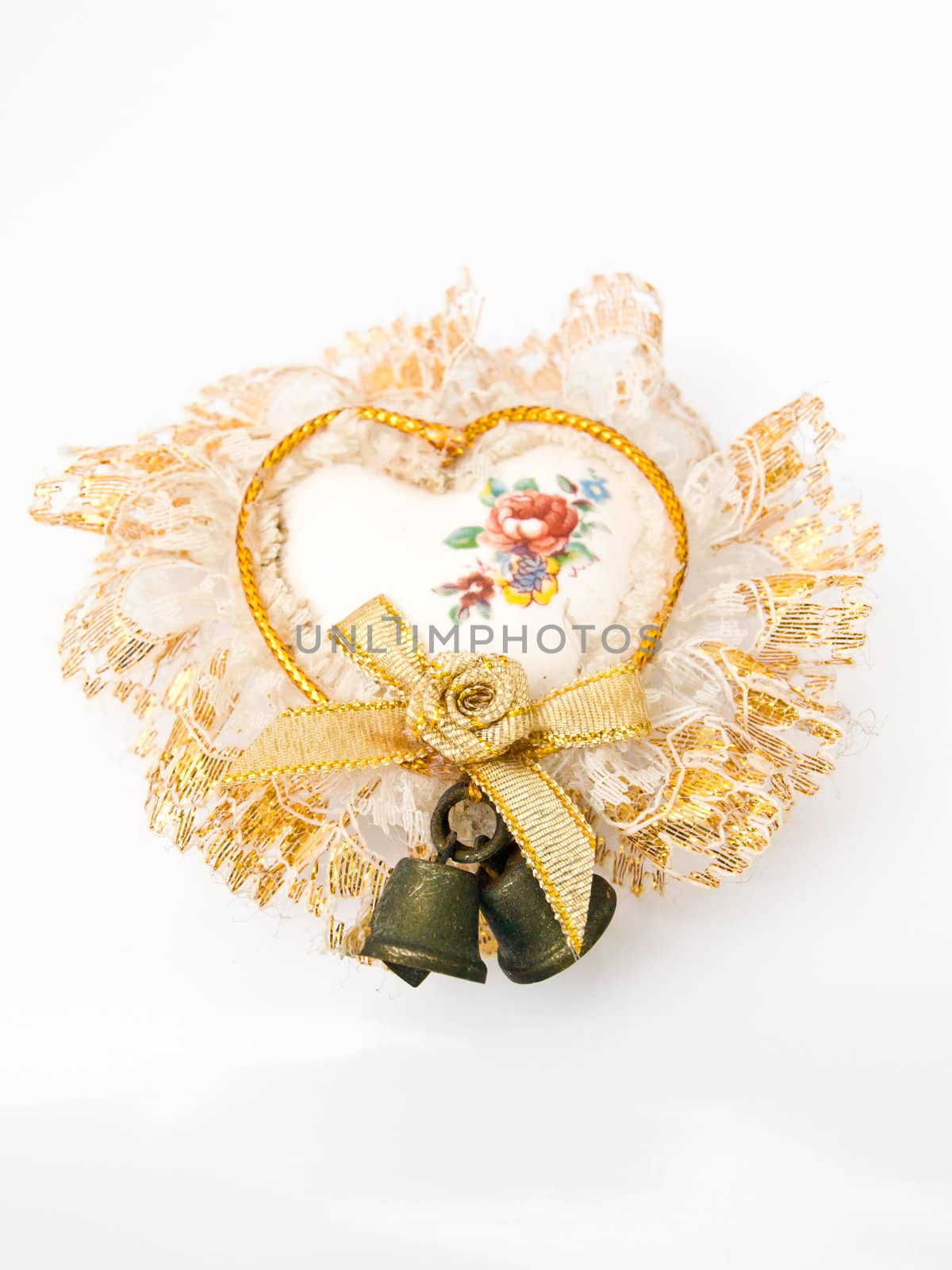 A ceramic heart decorated with bells and lace isolated on white by gururugu