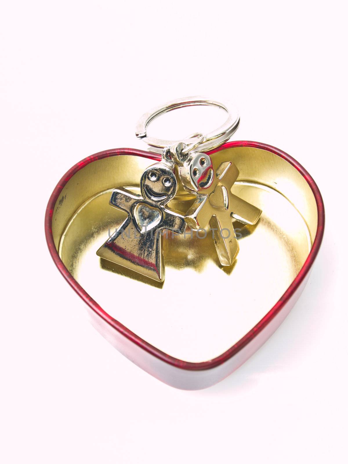 A golden stainless stell heart with a miniature groom and bride by gururugu