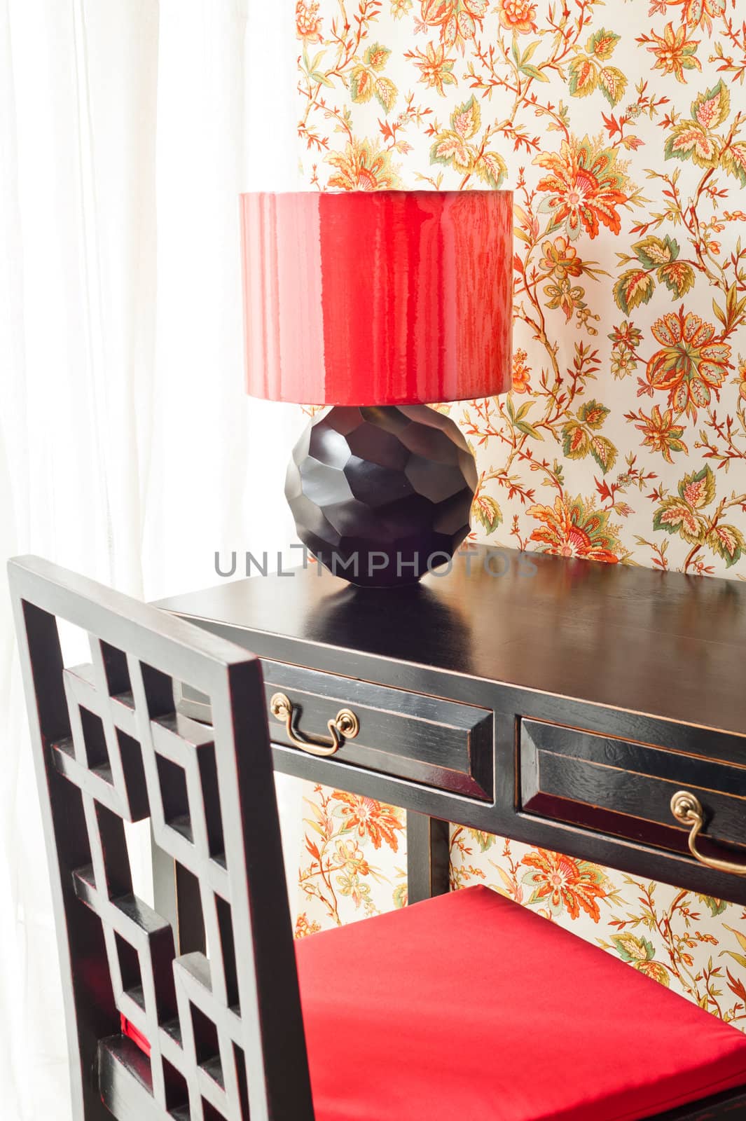 Luxury work desk with floral wallpaper next to bright window