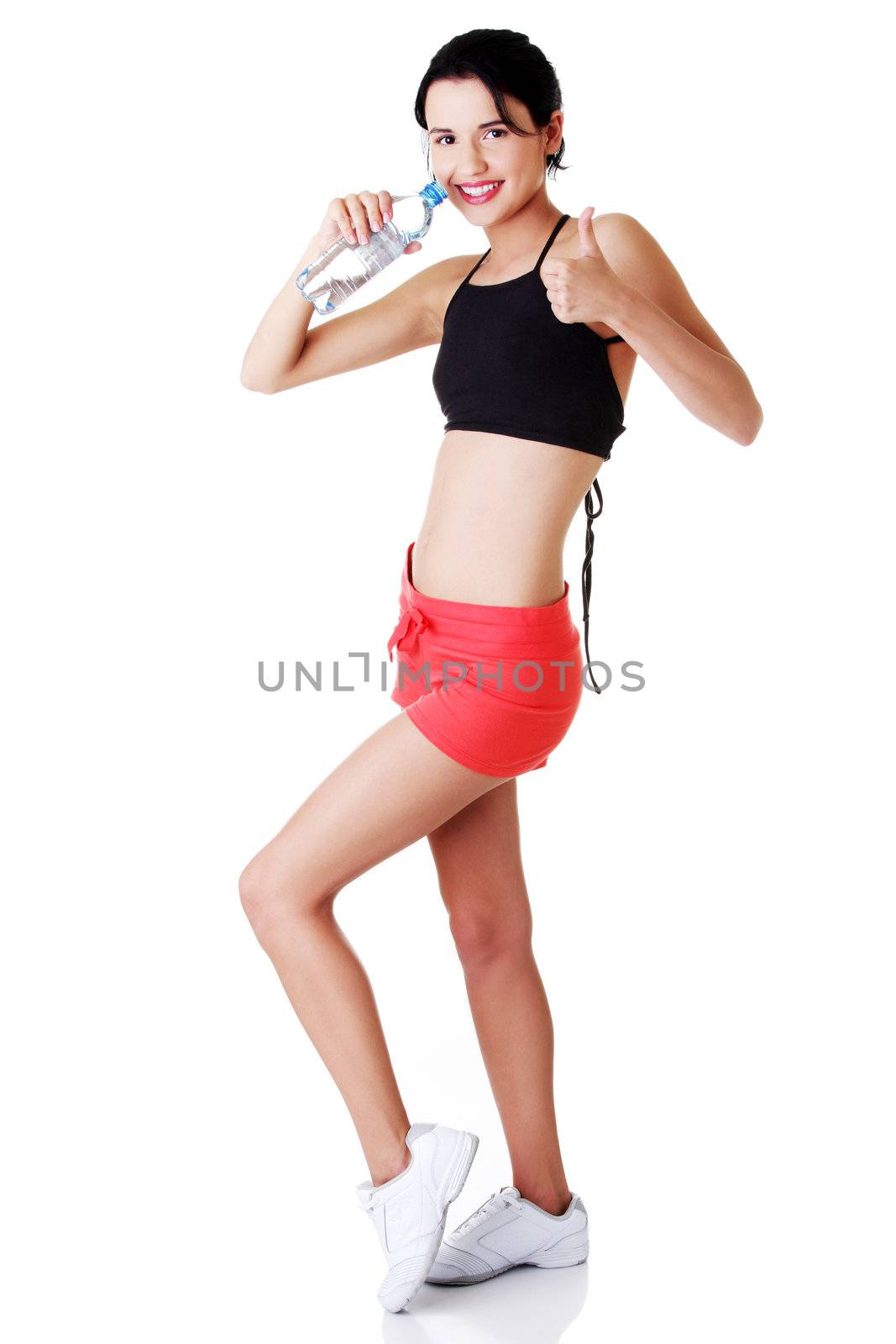 Young fit woman drinking mineral water by BDS