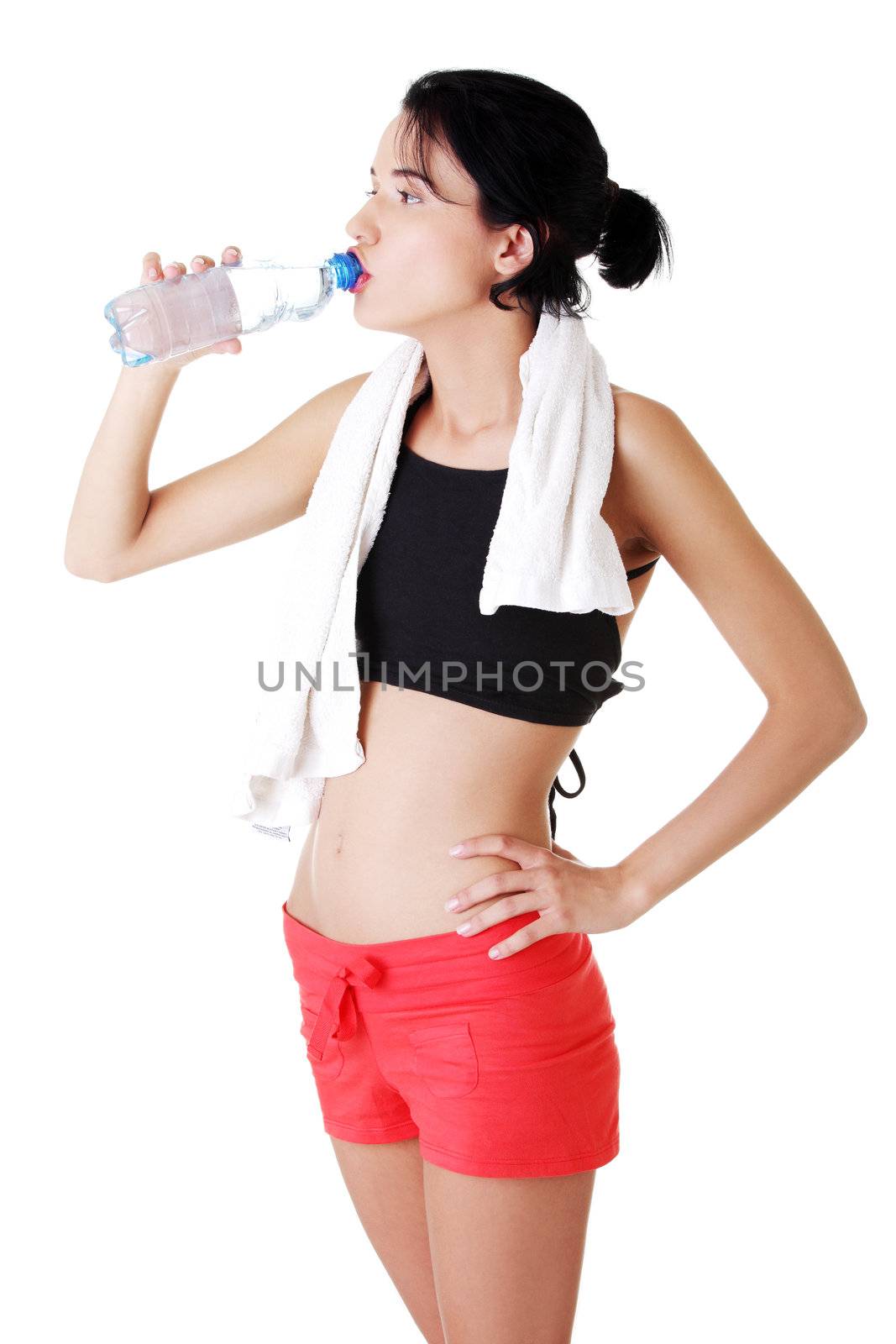 Young fit woman drinking mineral water after fitness exercise