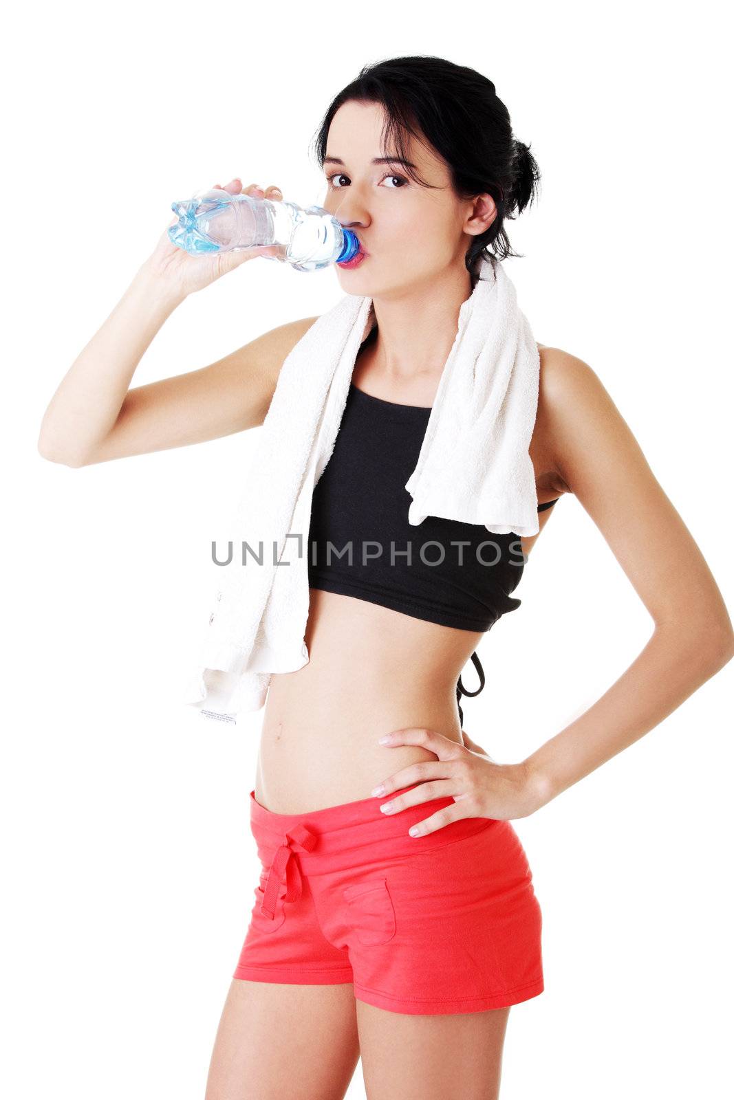 Young fit woman drinking mineral water after fitness exercise