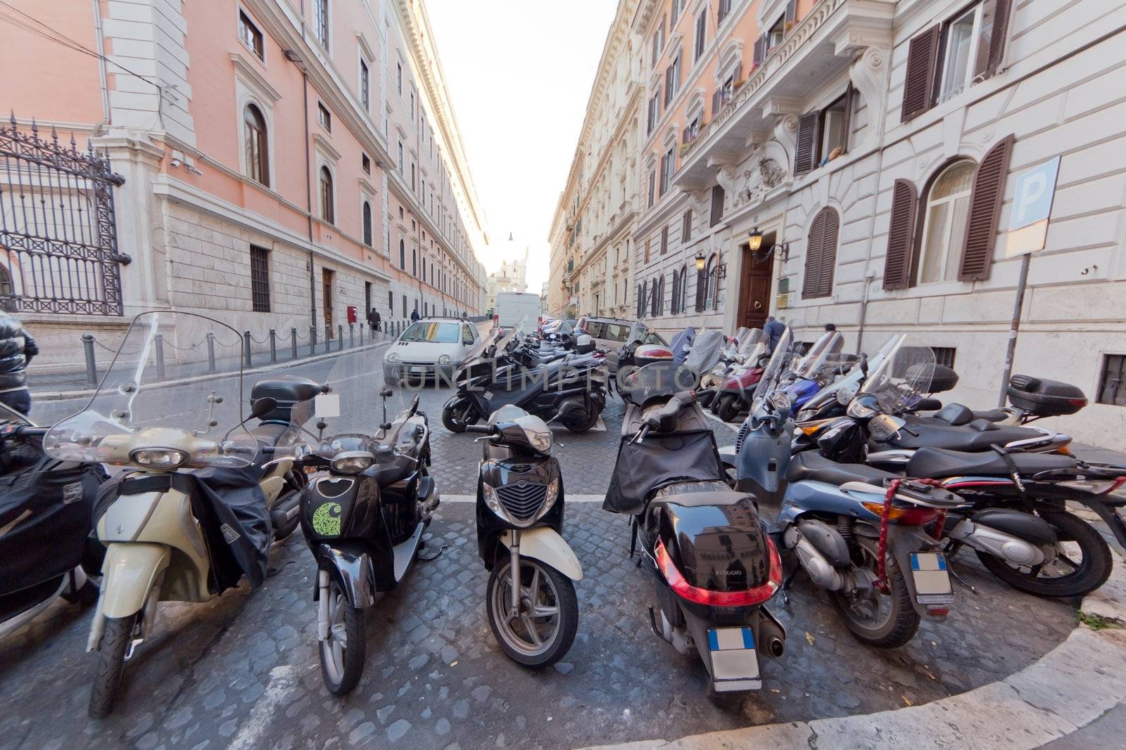 Many motorbikes parked in an alley in Rome, Italy