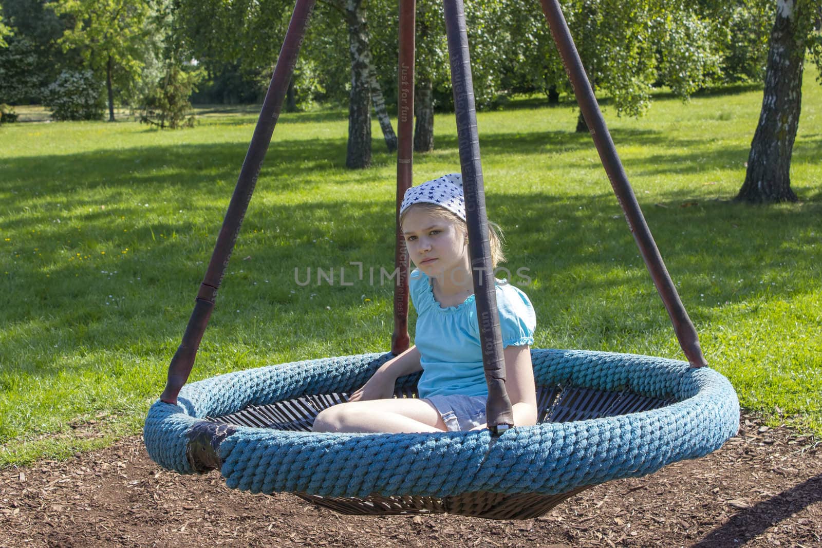 Young girl on swing in the park  by miradrozdowski