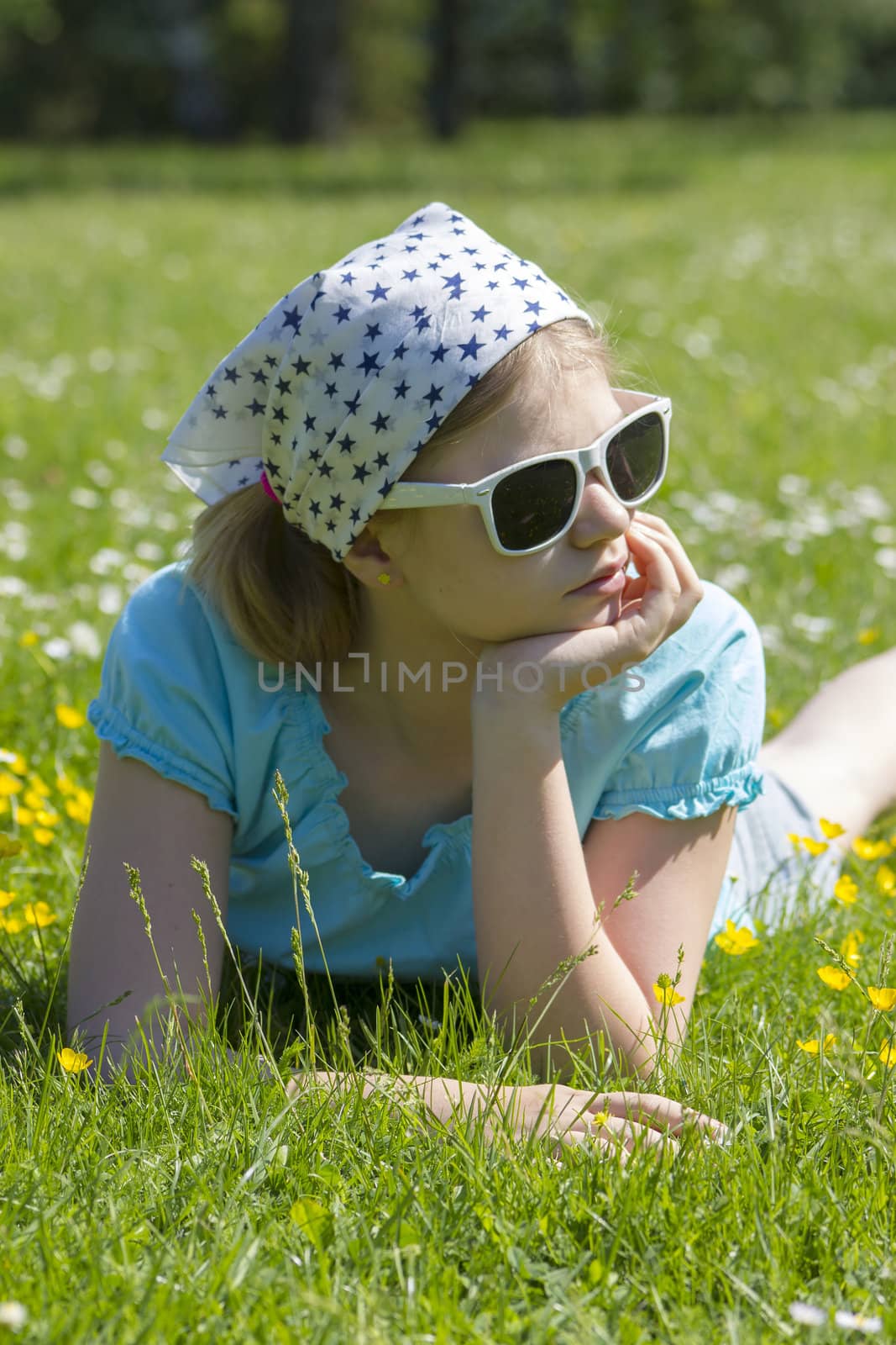 little girl lying on grass by miradrozdowski