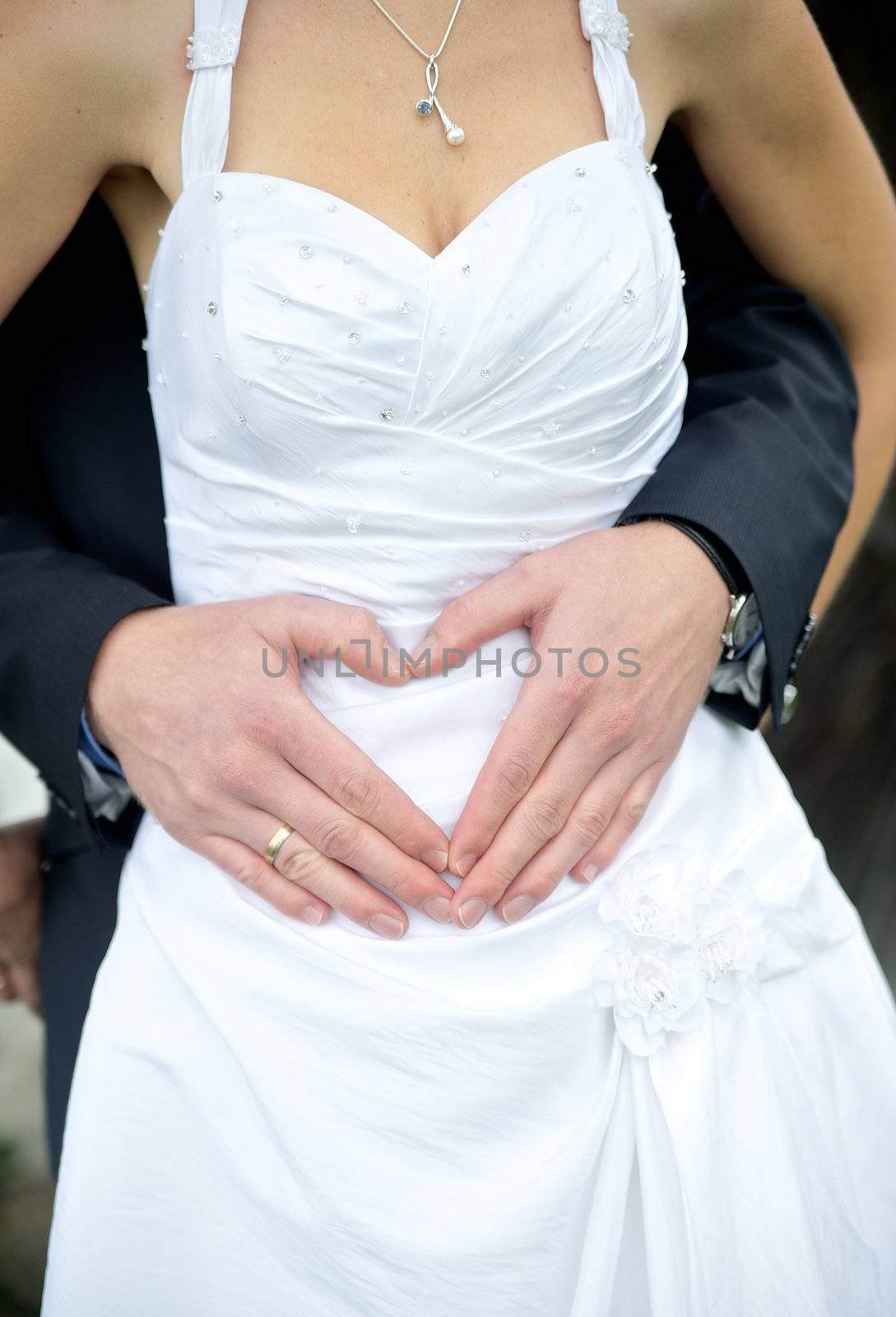 Wedding couple showing heart with their hands