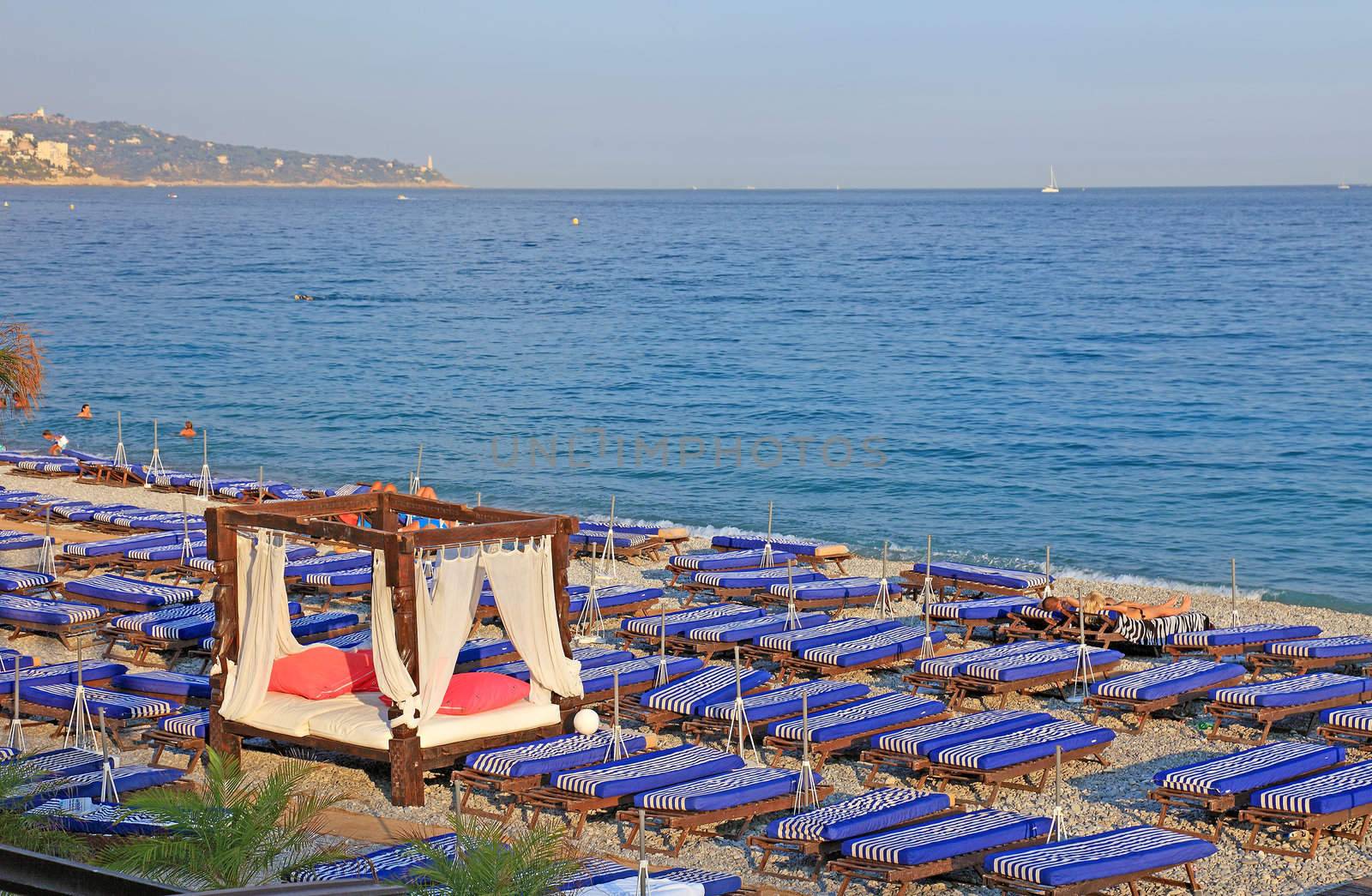 Lot of deck chairs with VIP o nthe beach of Nice city, France.