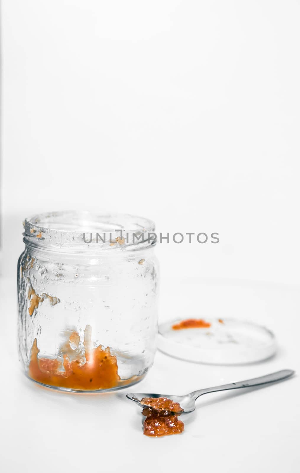 Empty marmalade jar and spoon isolated in studio