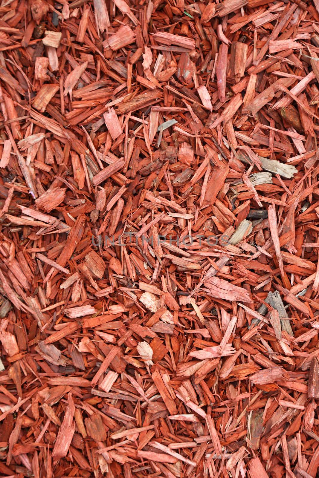 Red woodchips as textured background. by borodaev