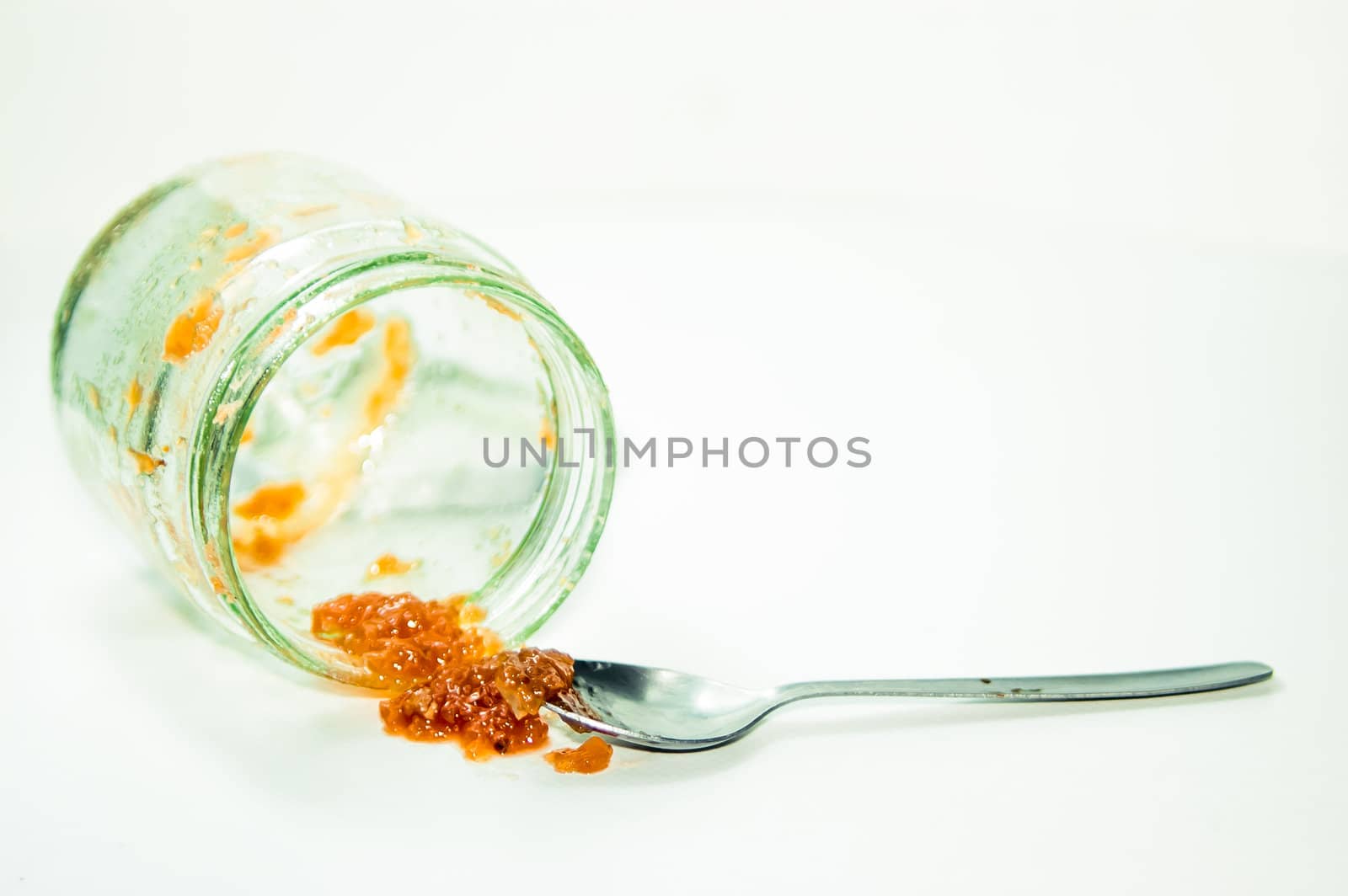 Empty marmalade jar and spoon isolated in studio