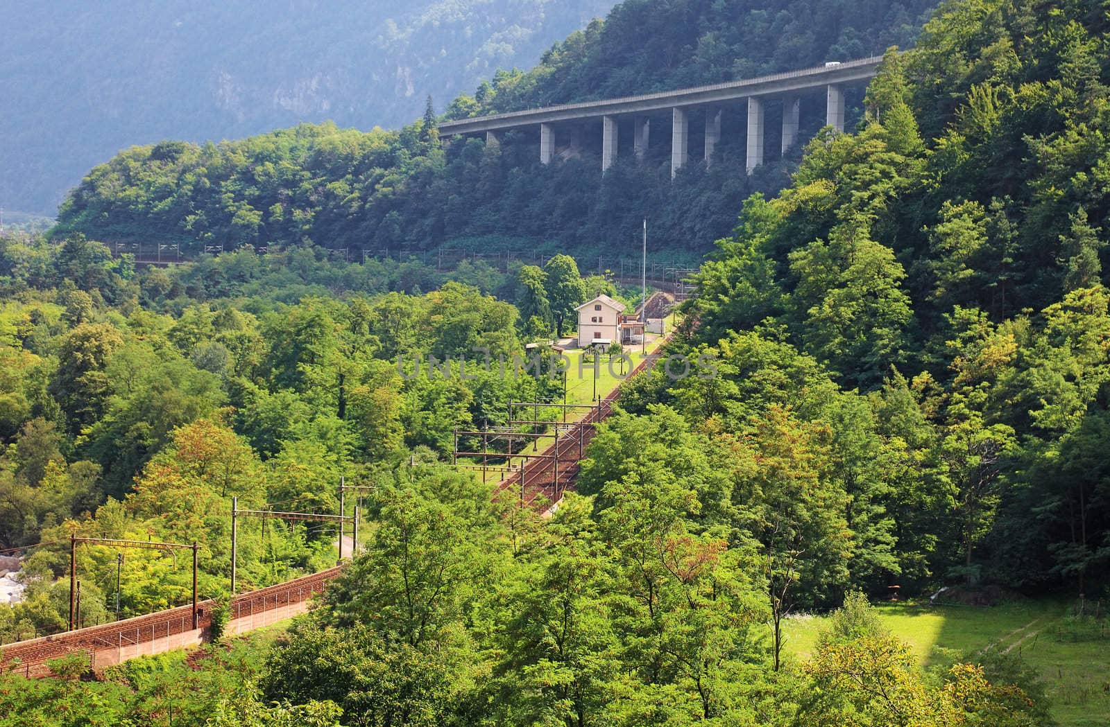 Railroad and new road in Swiss Alps, Europe.