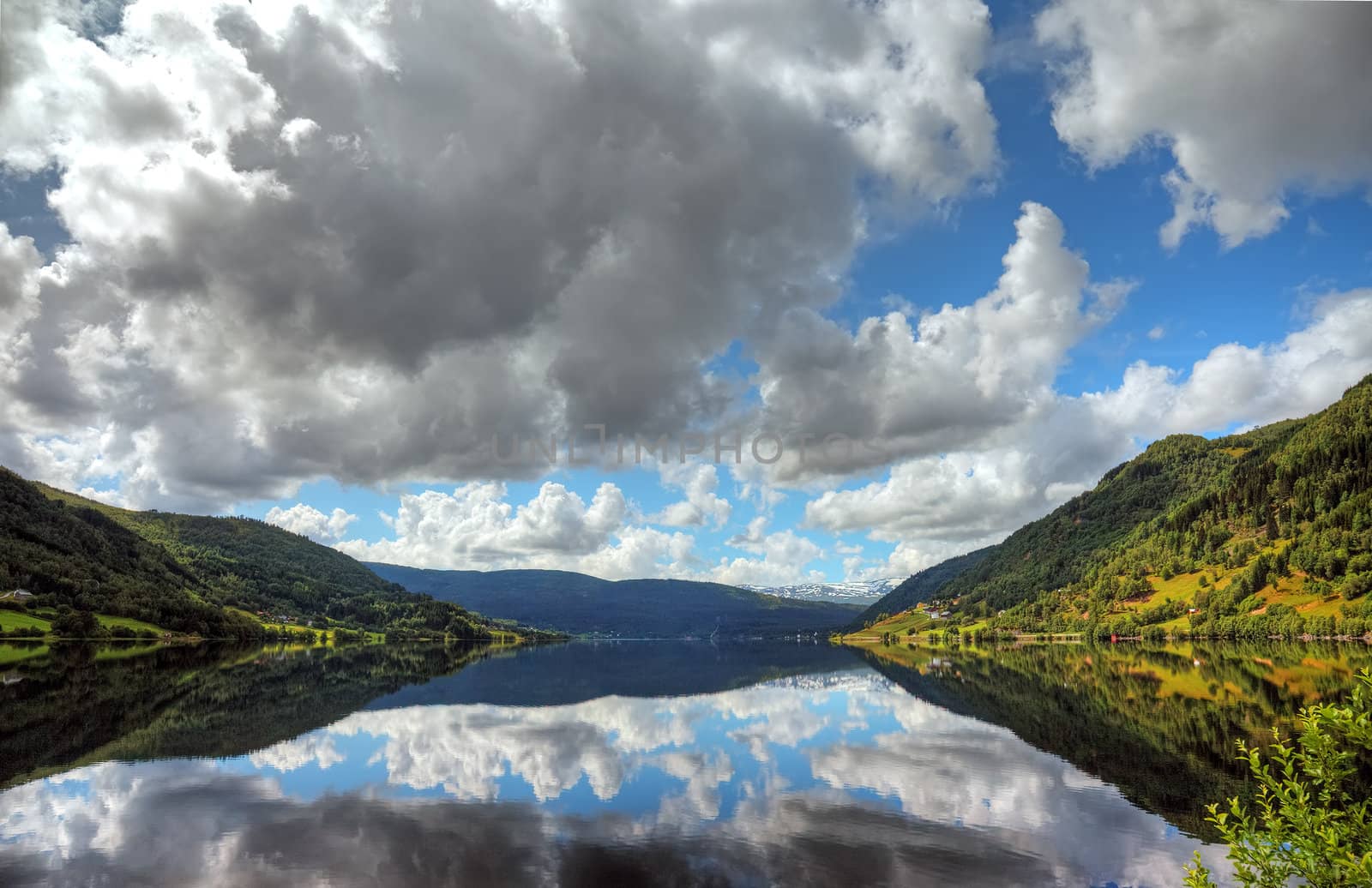 Beautiful norwegian lake with reflection of dramatic sky, scandinavian Europe.