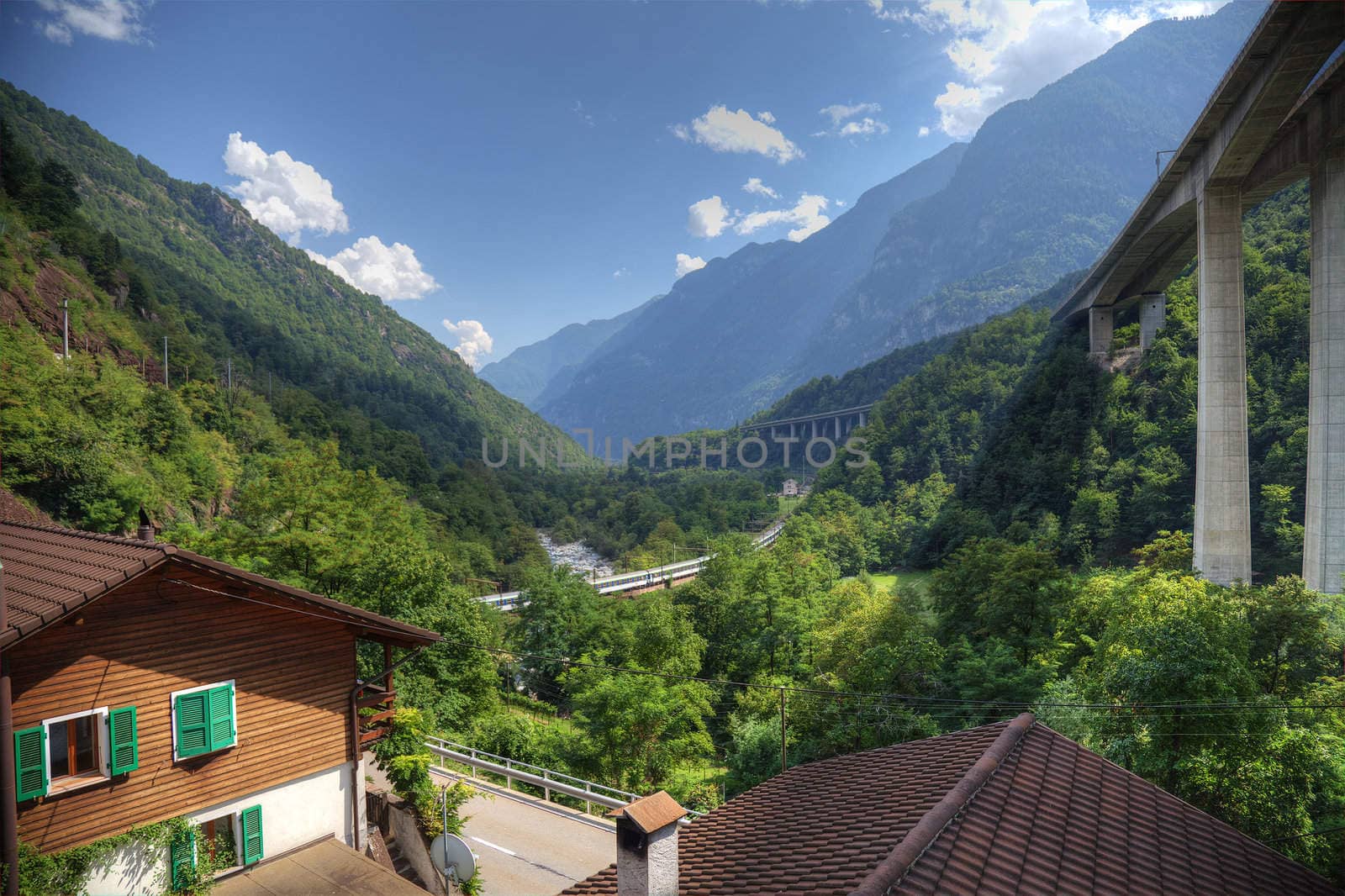 Modern alpine valley  with highway and railroad in Switzerland,  by borodaev