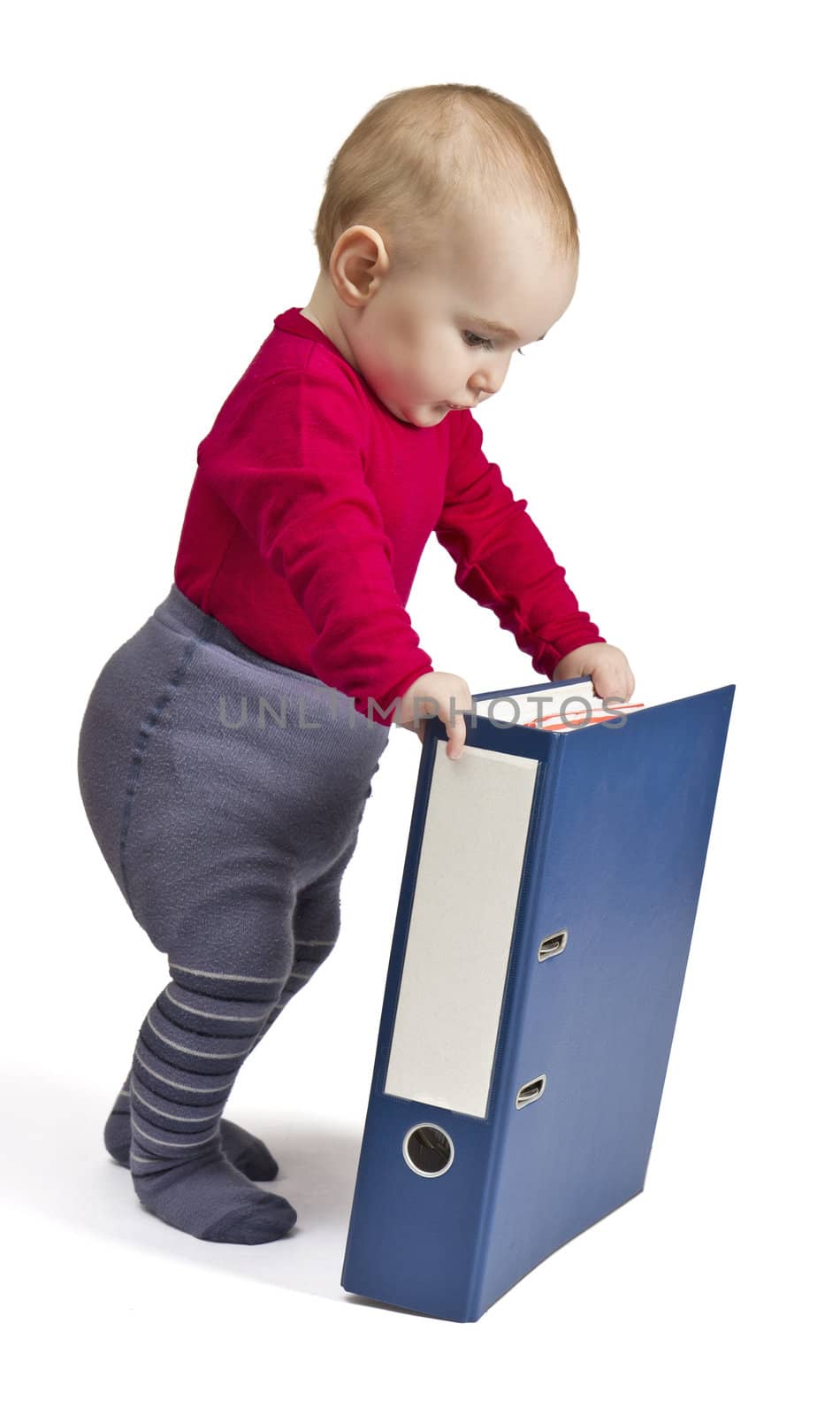 small child in red shirt standing next to blue ring binder. white background with shadow