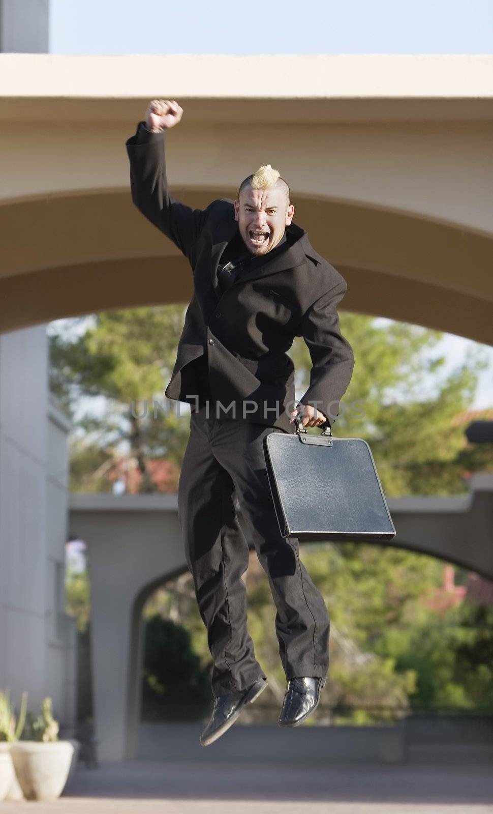 Business man with a punk haircut jumps up.