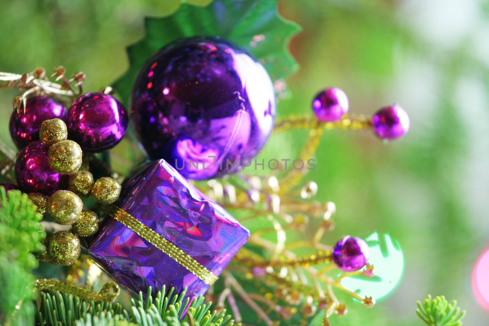 Purple present ornament nestled in CHristmas tree.