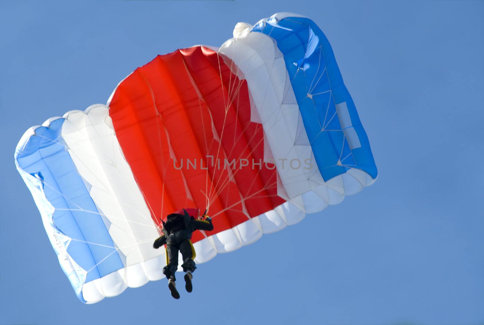a parachutist pulling brakes above us