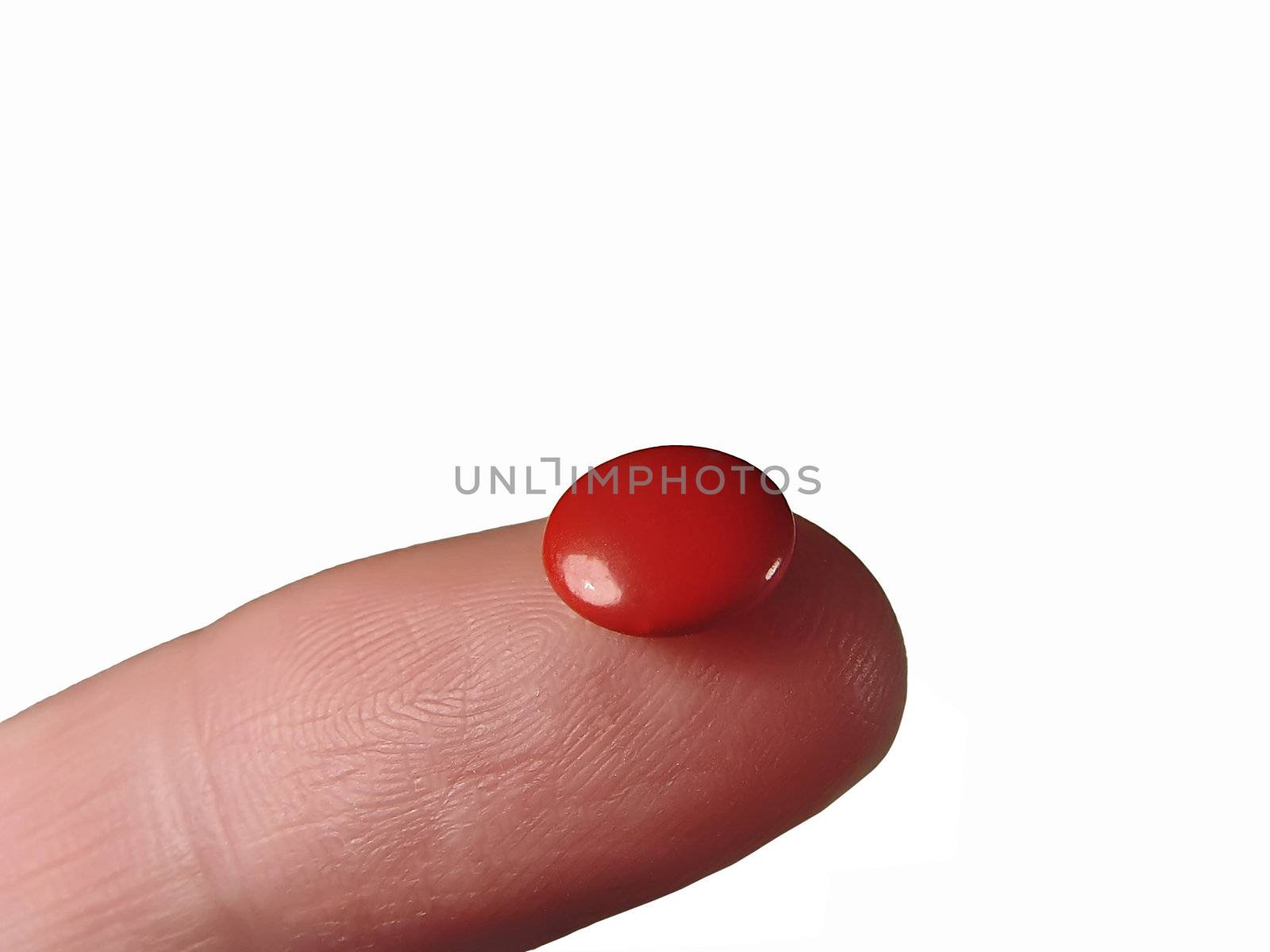a red pill on the top of a finger