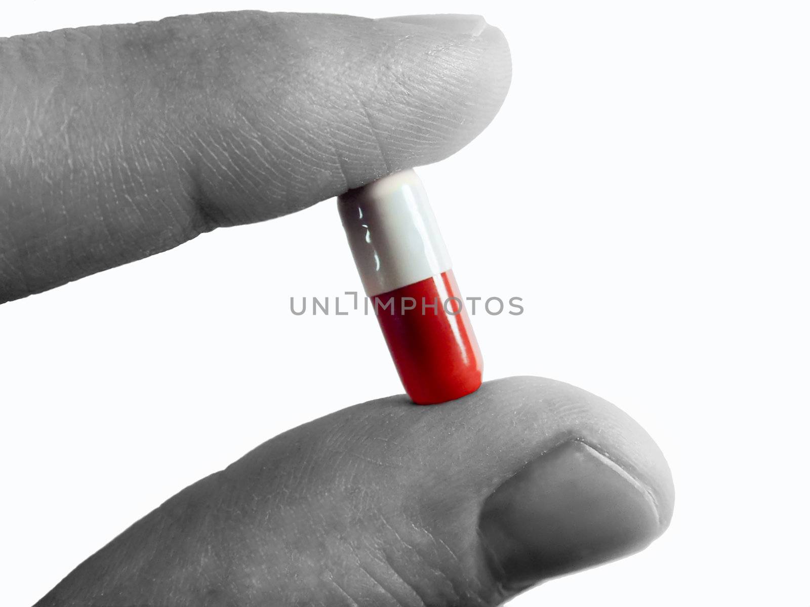 a capsule between a finger and a thumb