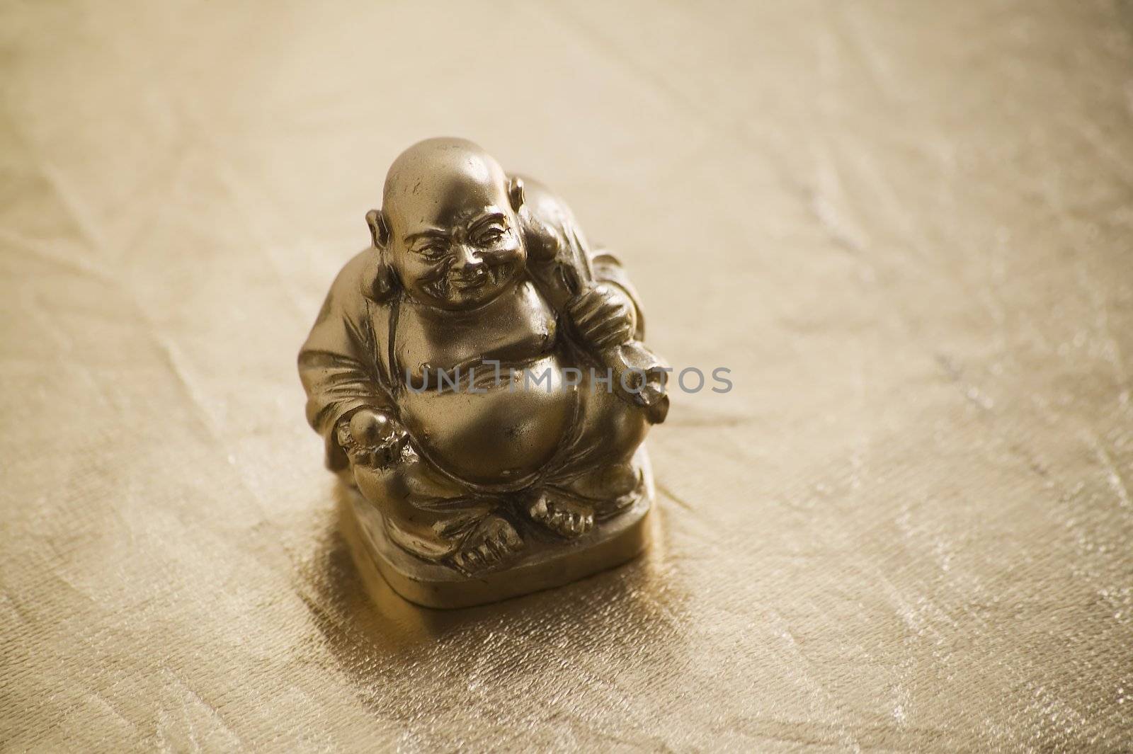 Gold painted buddha figure on a shiny surface.