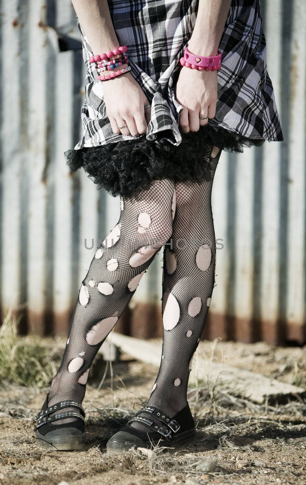 Hem of a dress and woman's legs with ripped stockings
