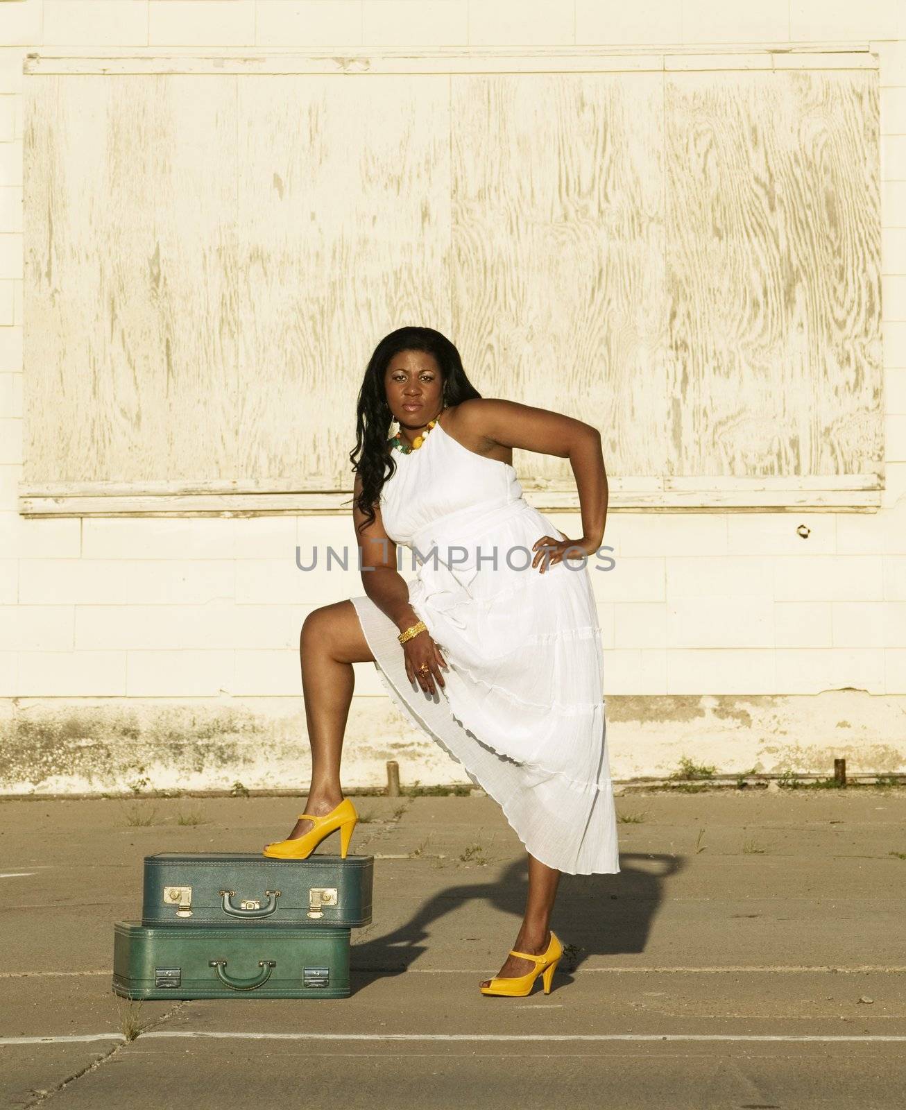 African American woman showing her leg along the side of a road.