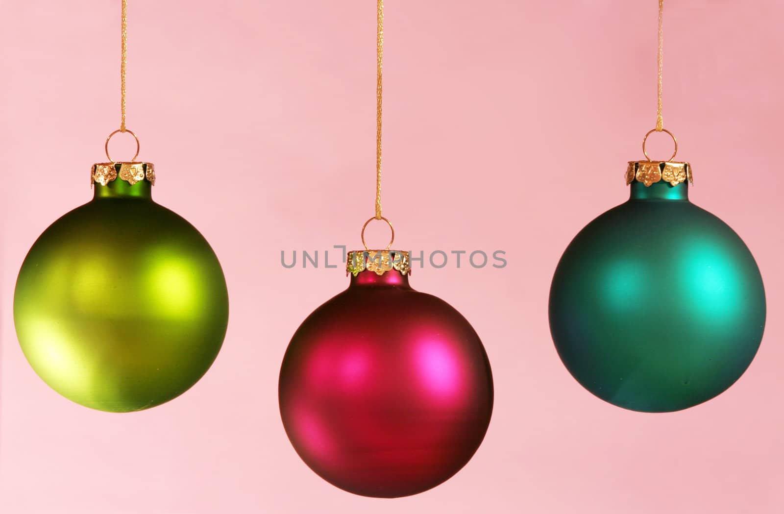 Three colorful ornaments on light pink background. by jarenwicklund