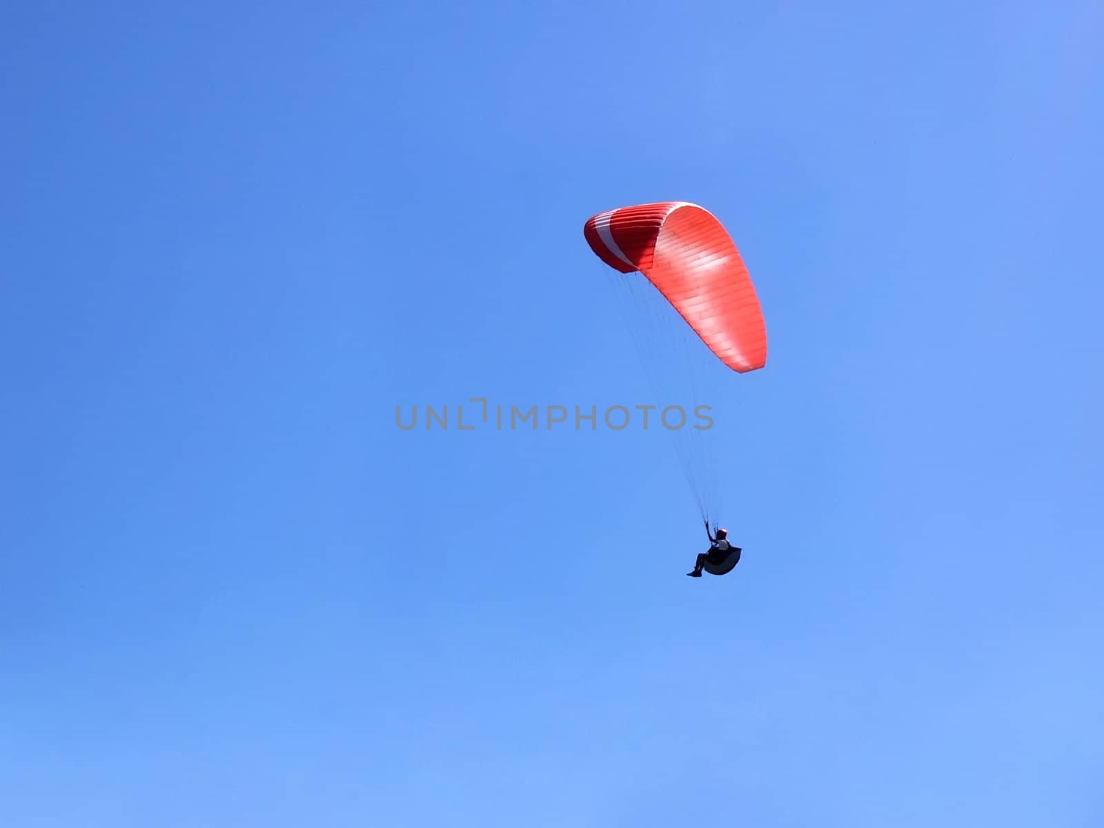 Paraglider flying over us in the blue sky