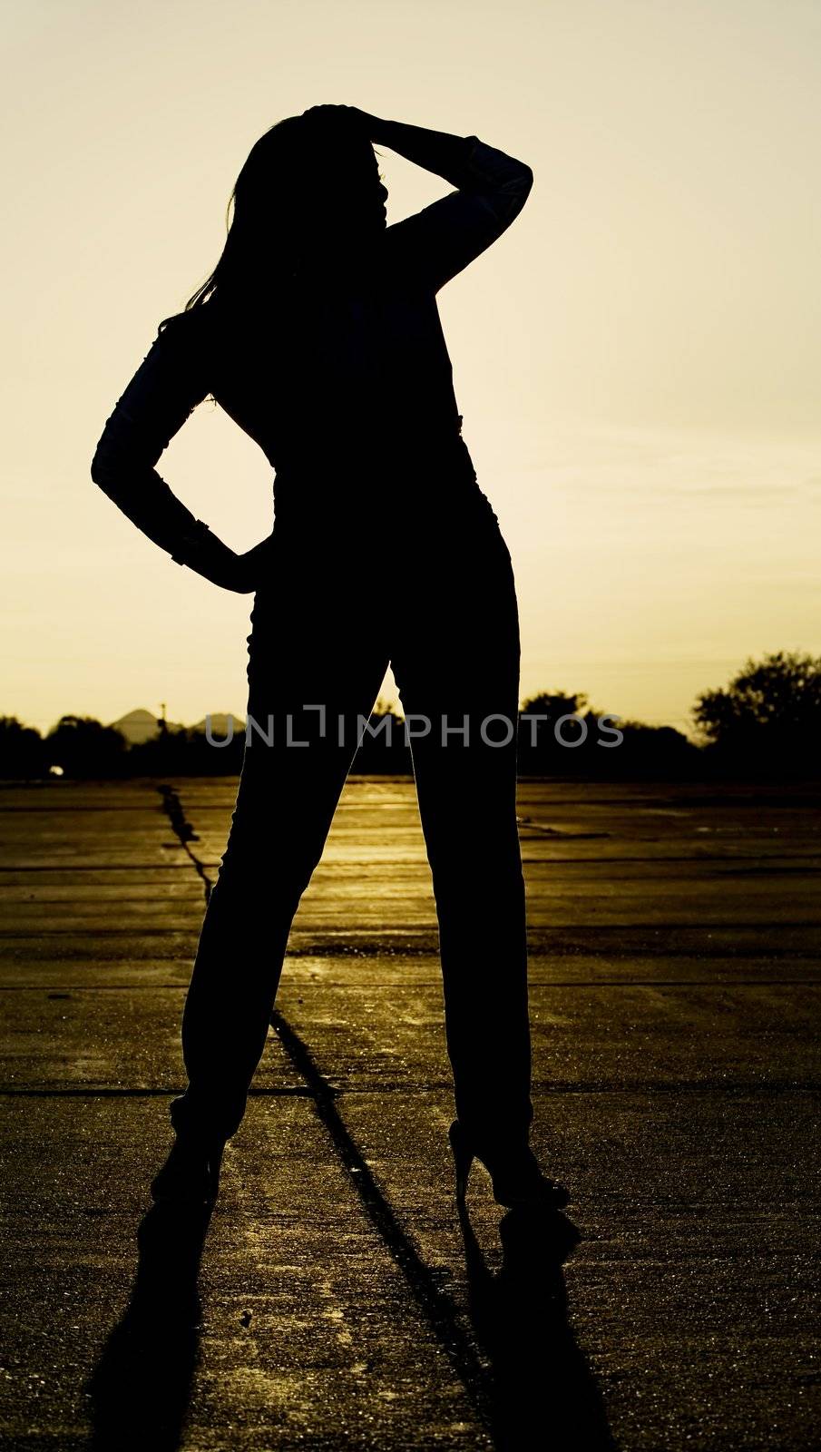 Woman silhouetted at sunset. by Creatista