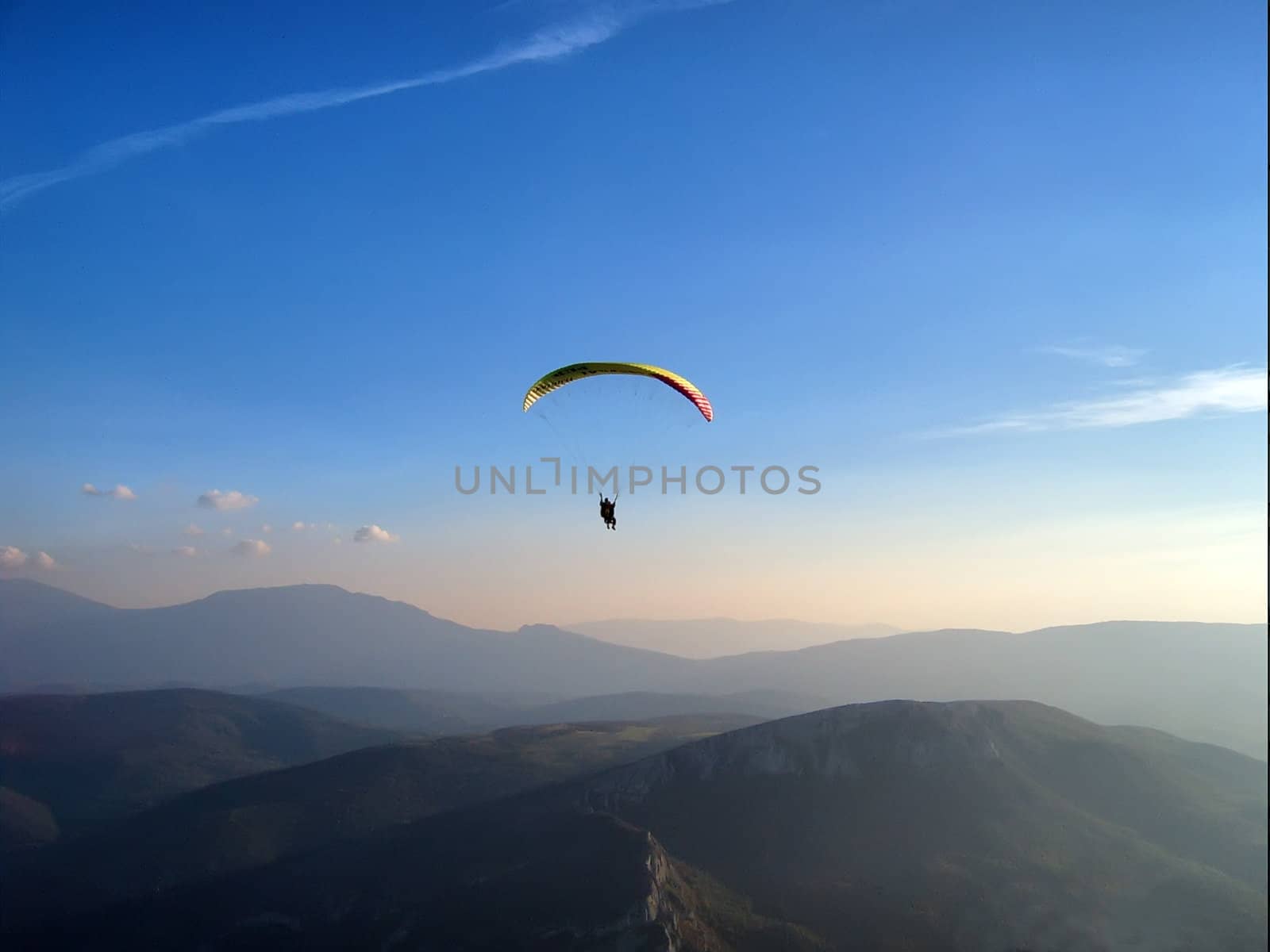 a paraglider is flying in a twilight