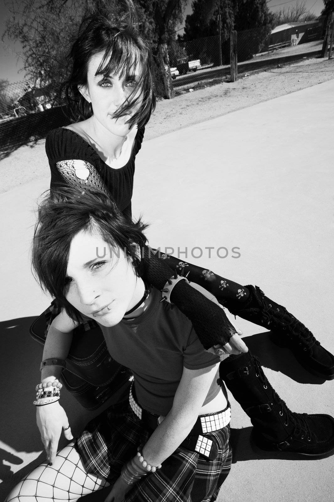 Two Punk Girls Sitting on a cement playground