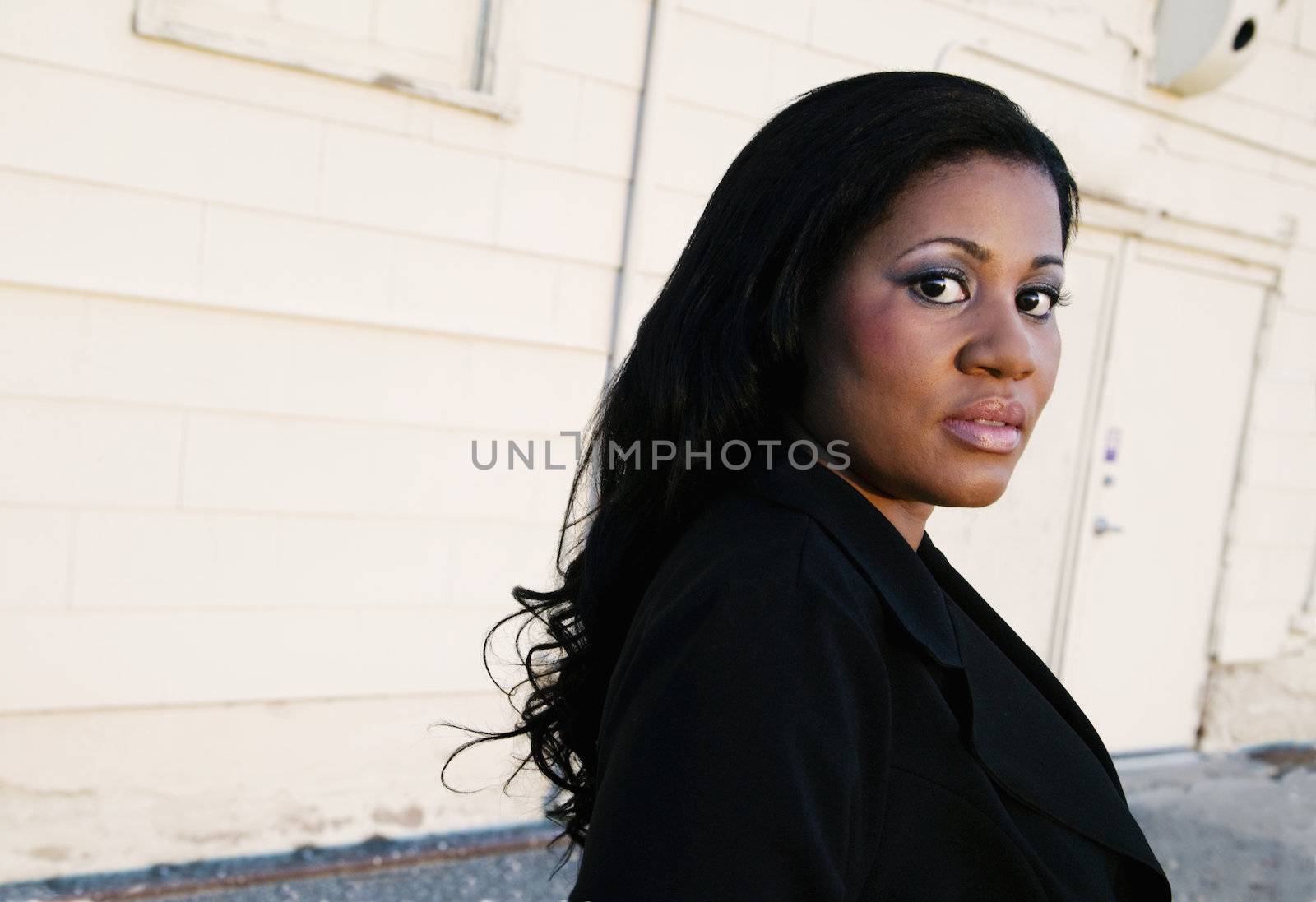 African America business woman in front of an industrial building.