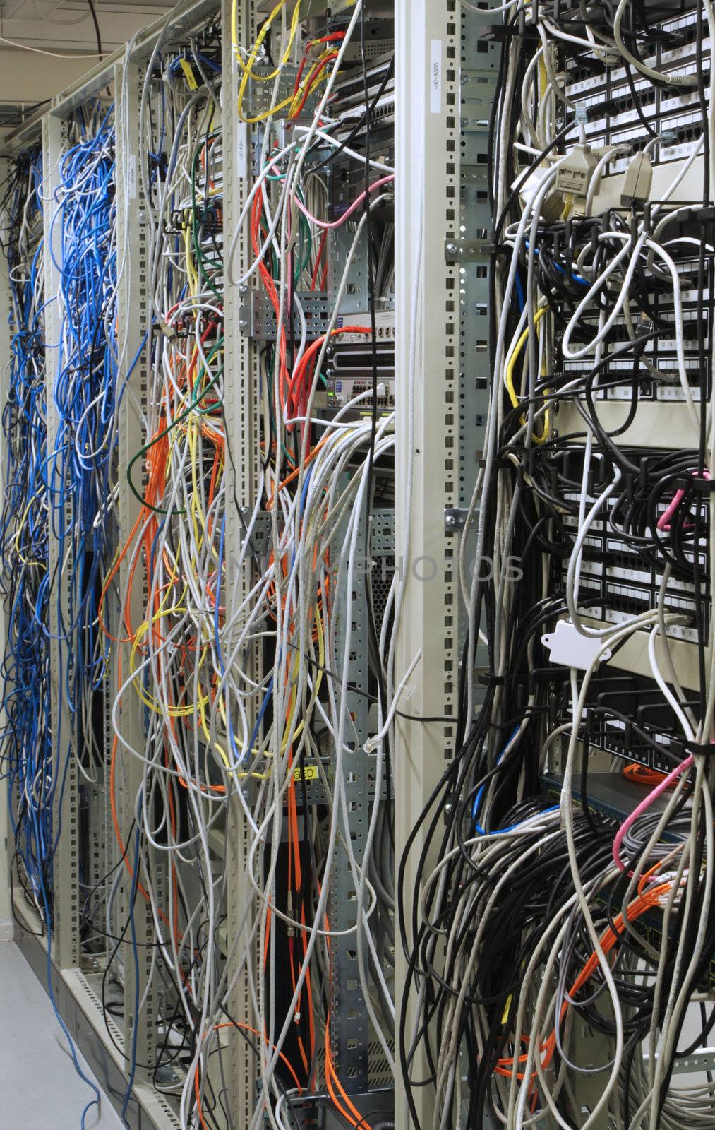 chaotic mess of network cables connected to network routing switches 