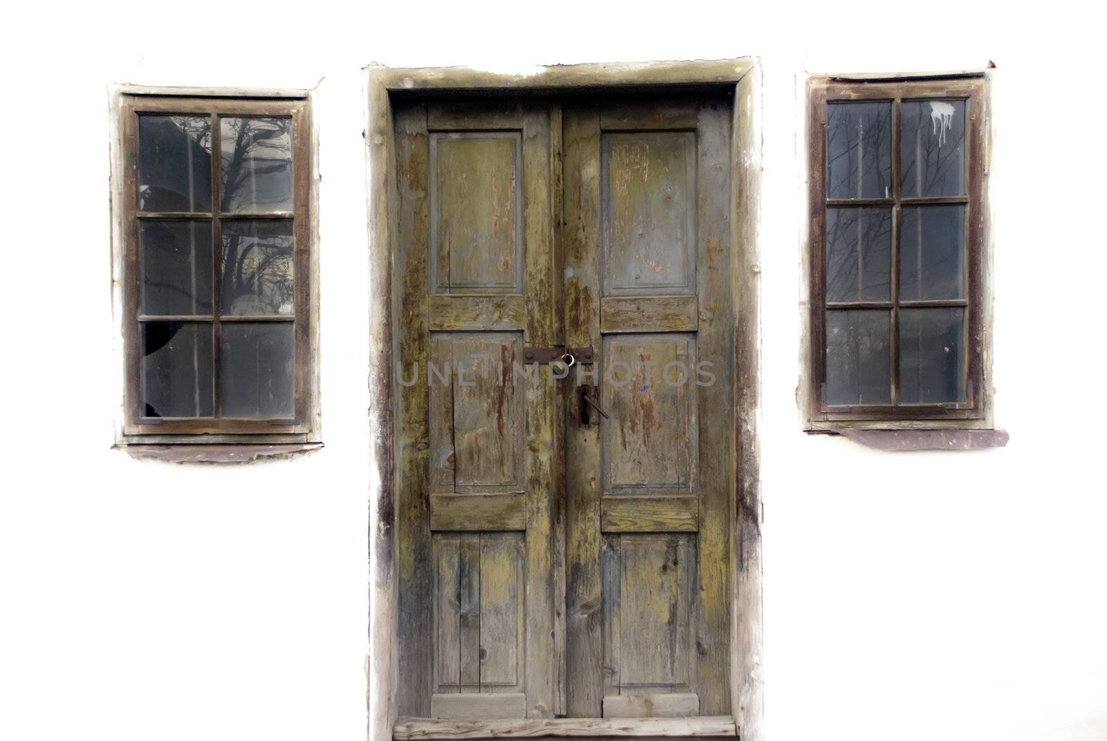 Door and two windows on an old abandoned house