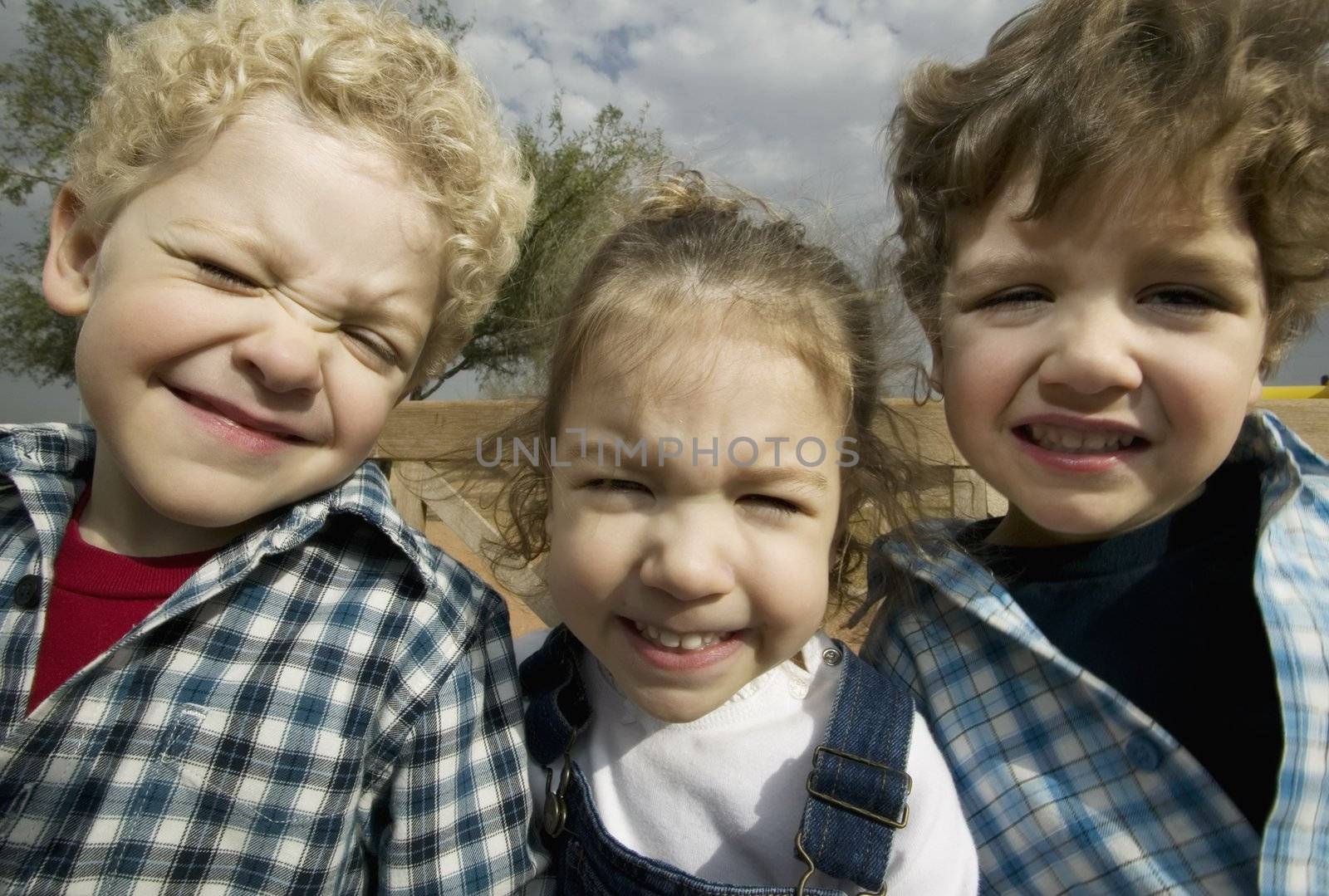 Triplets make faces in a wide angle portrait