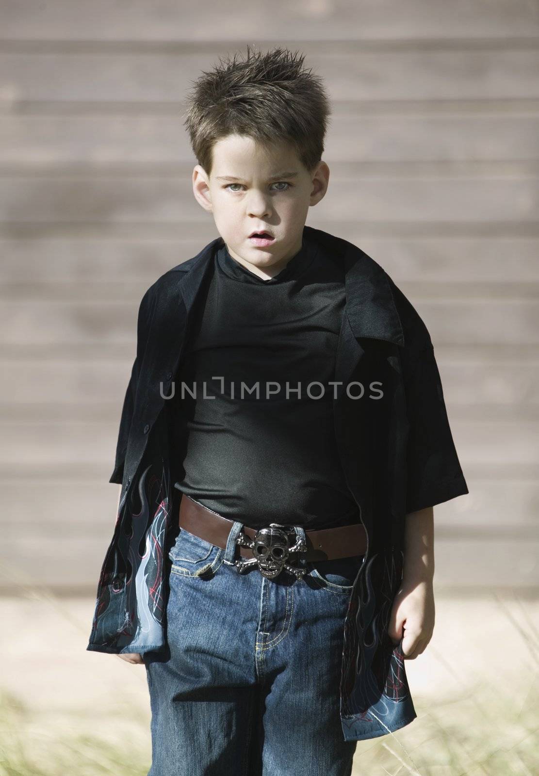 Young boy with a defiant attitude wearing a black shirt and a pirate belt buckle.
