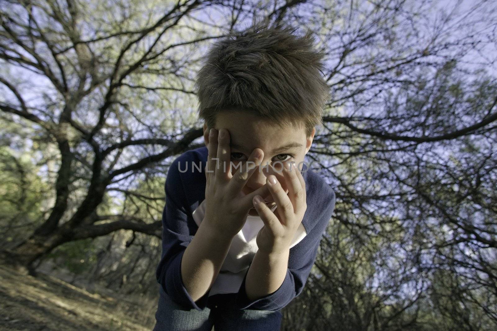 Boy covers his face with his hands