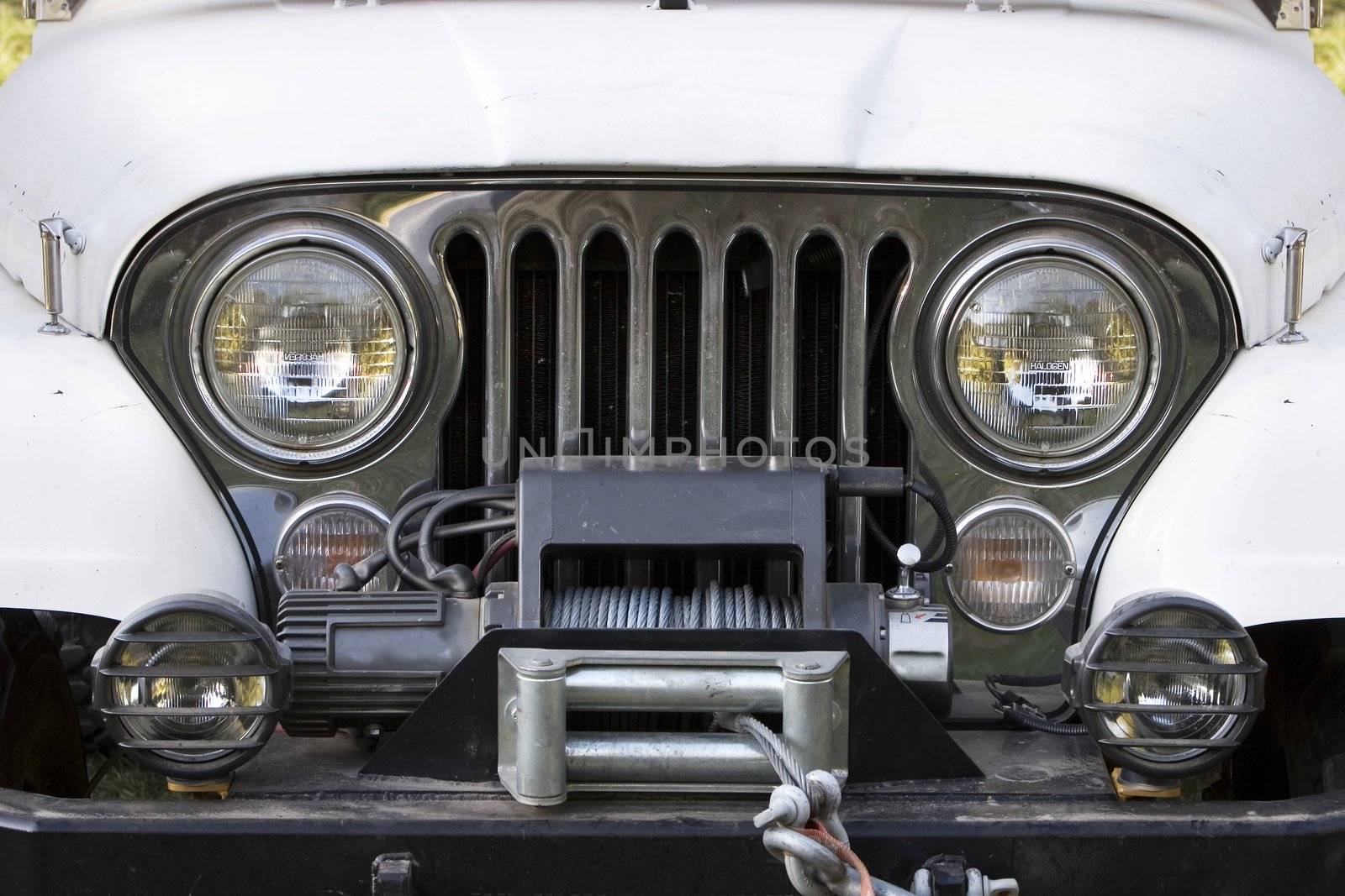 Front end, headlights and grille on a vintage four-wheel drive vehicle.