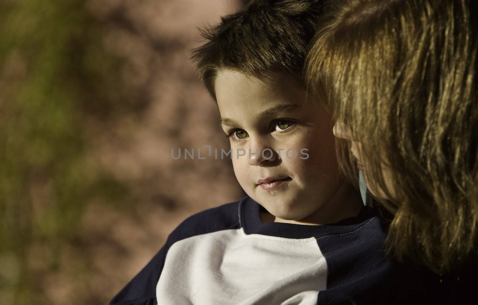 Young boy with his mother looks to the distance.