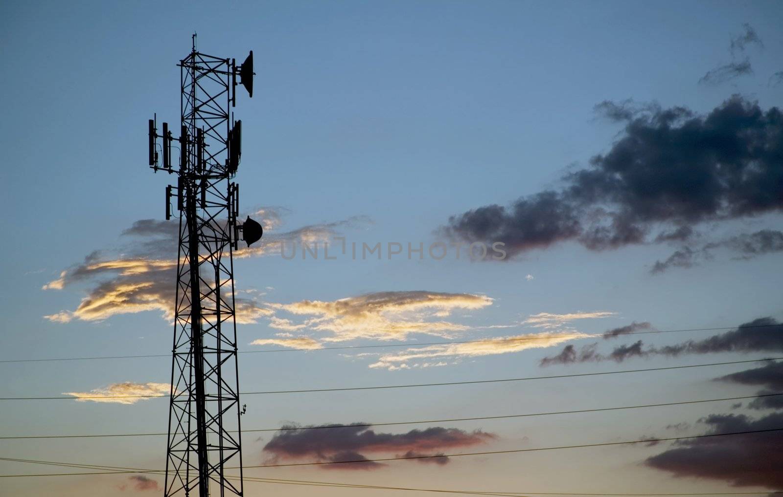 Communications tower silhouetted against a late evening sky.