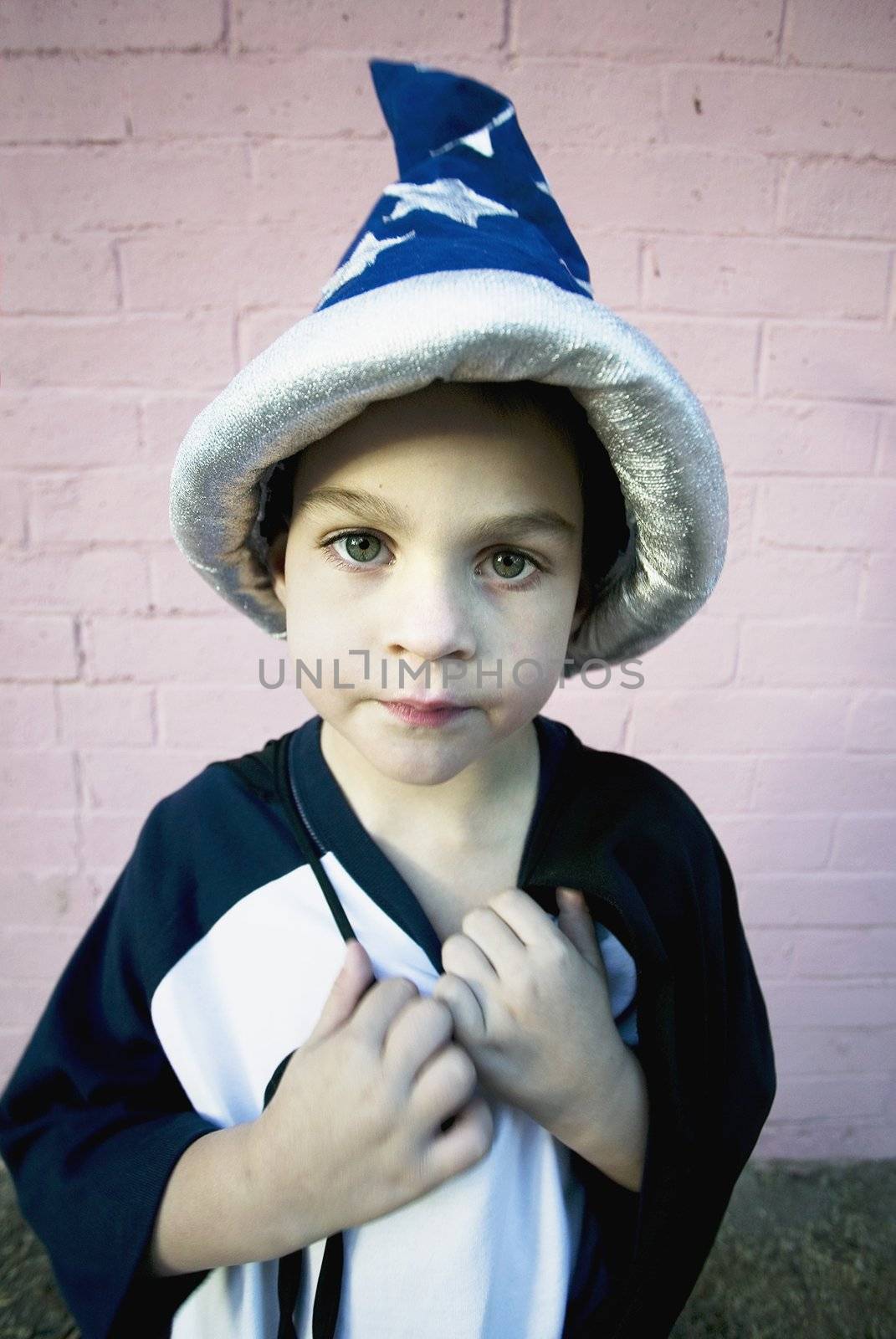 Young boy in a wizard costume pulling at his string tie