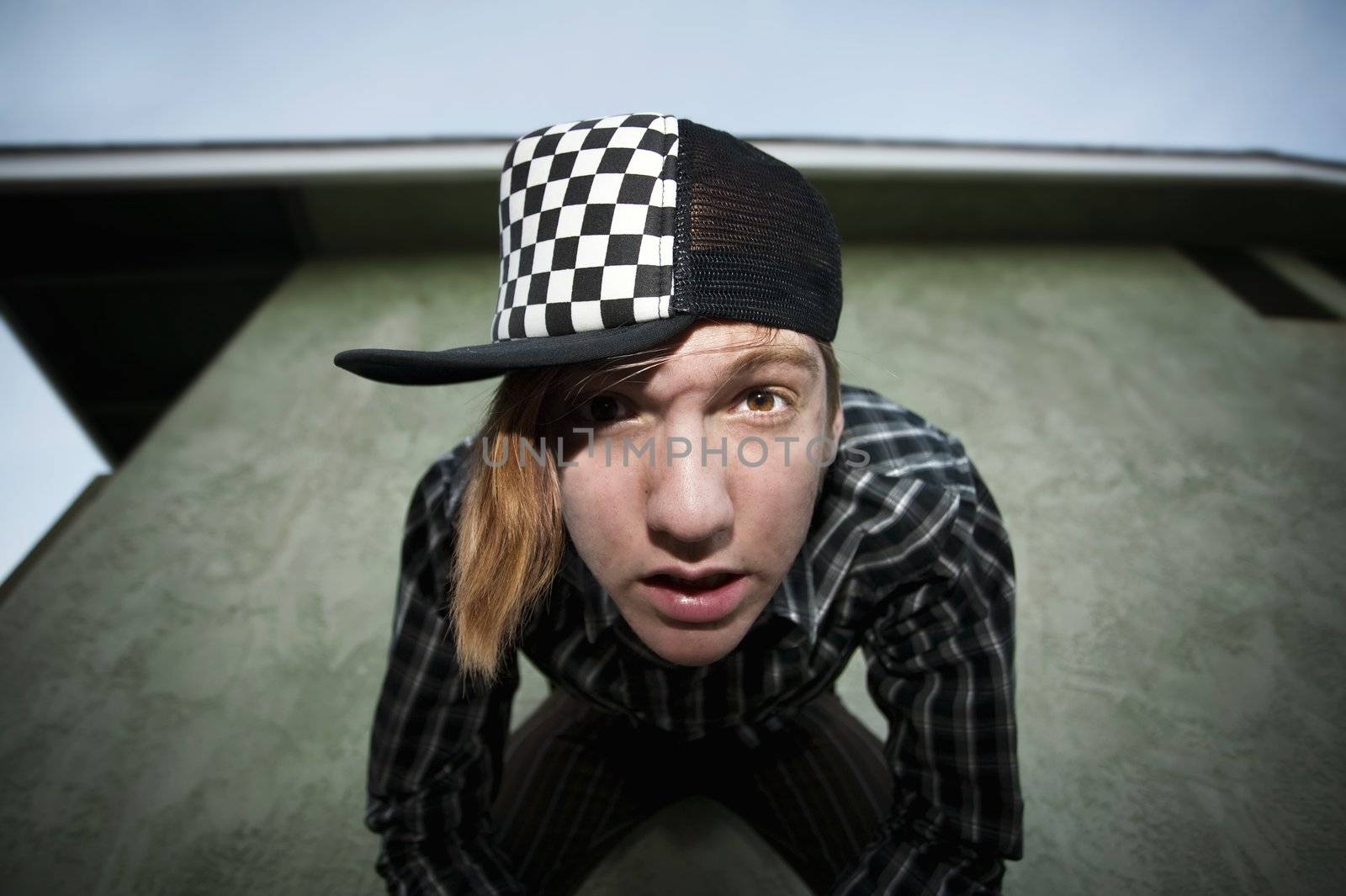 Wide angle shot of a teenage in front of a green stucco wall shot with a flash