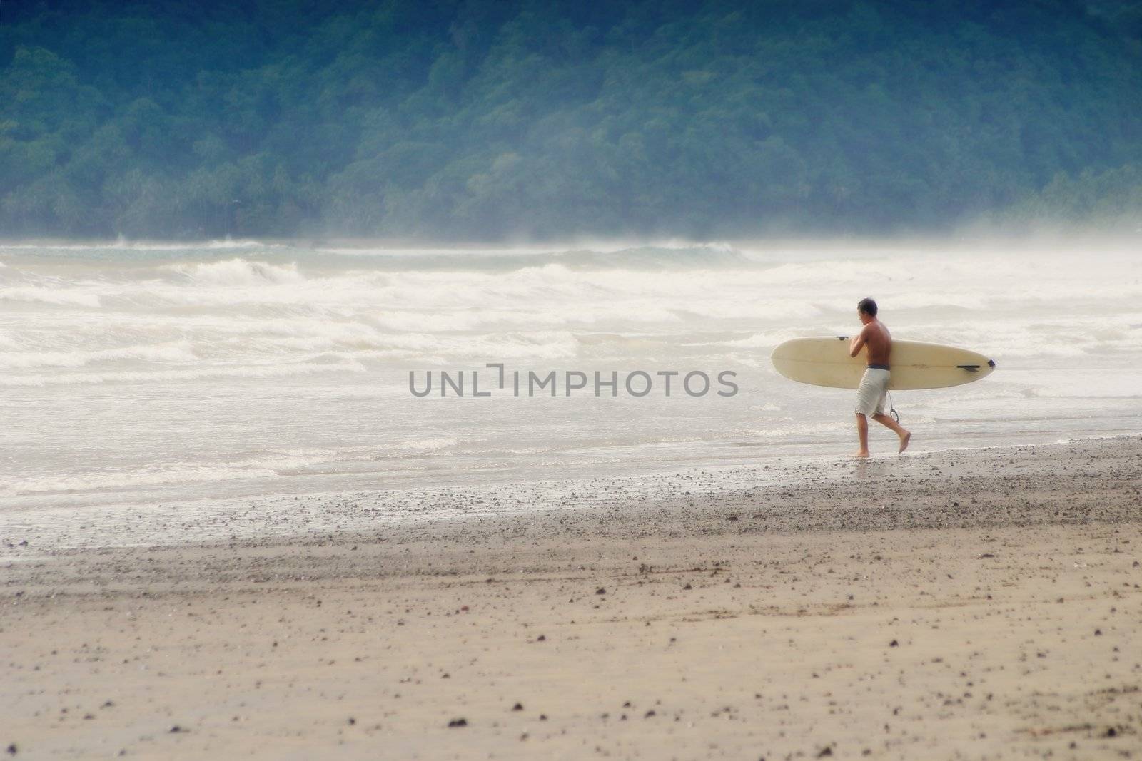 Surfer with his board heads for the water.