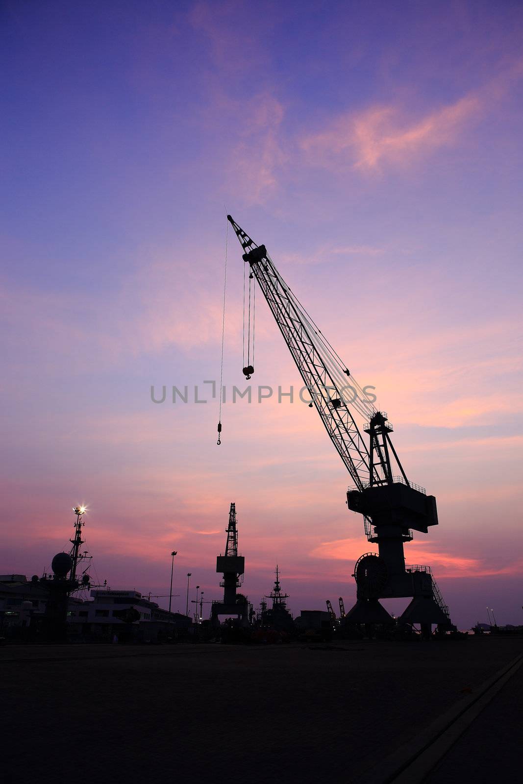 Cranes in dockside at sunset by rufous
