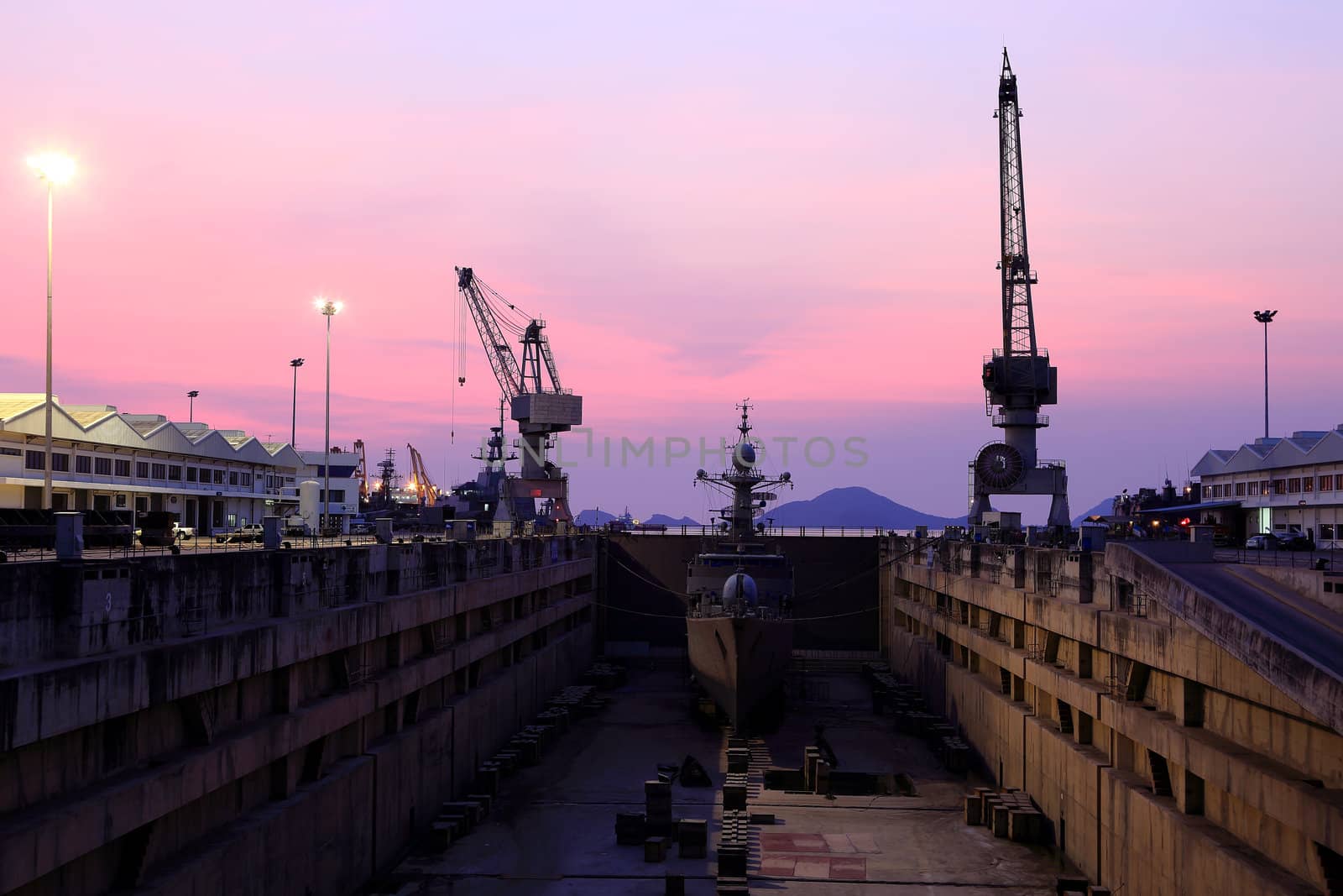 Crane near a covered dry dock at the shipyard by rufous